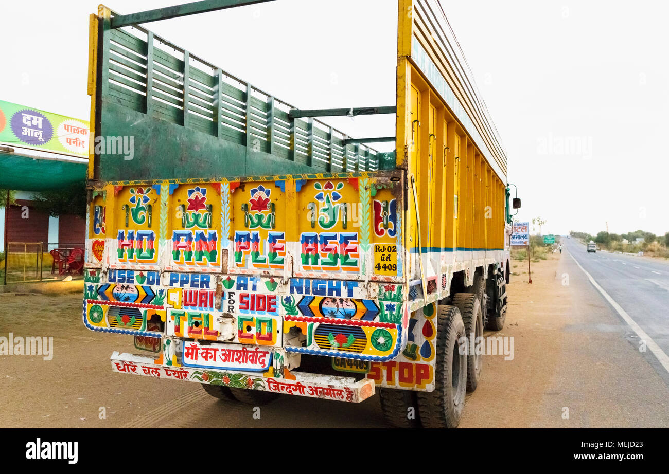 Autofahren in Indien: Blick auf einen typischen hell Zurück farbige eines indischen Güterkraftverkehr Lkw am Straßenrand geparkt, Dausa, Rajasthan, Nordindien Stockfoto