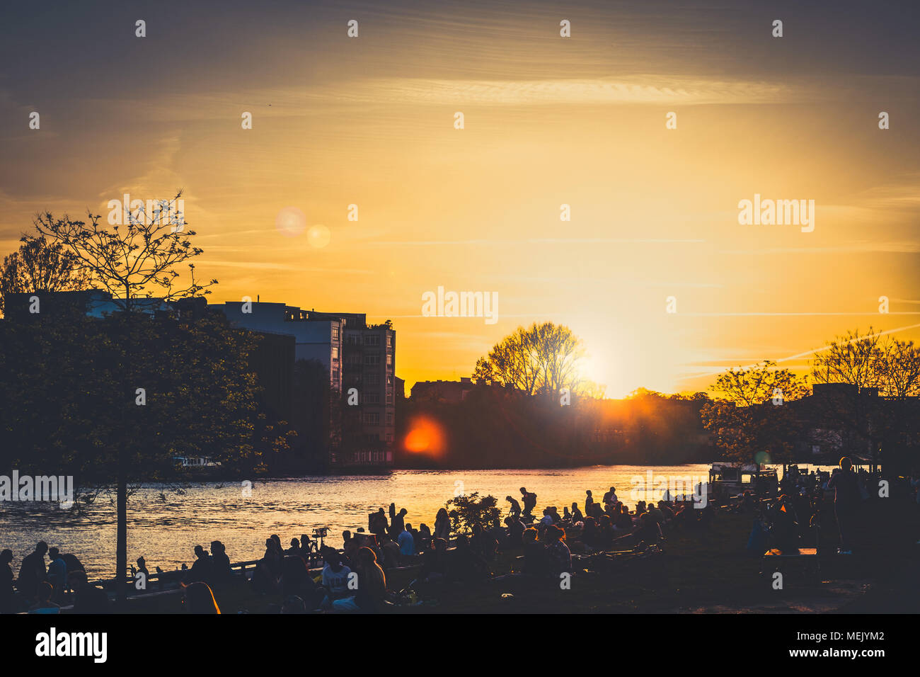Berlin, Deutschland - April 2018: Junge Menschen zu Fuß an der Berliner Mauer (East Side Gallery) auf Sommer Tag abends bei Sonnenuntergang Himmel Stockfoto