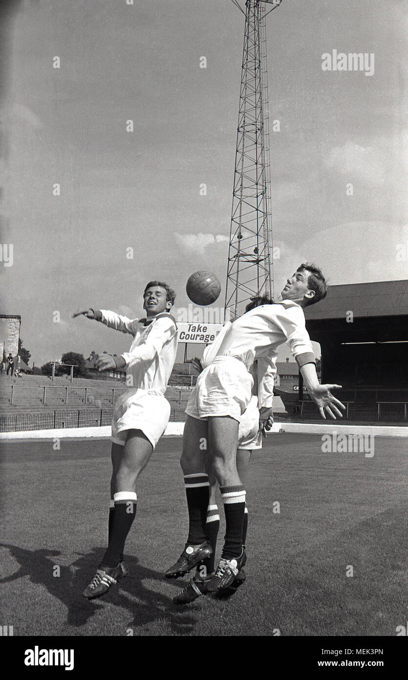 1964, Charlton Athletic FC, historische Bild, Charlton Spieler im Tal das Springen mit der Kugel tragen ihre neuen Fußball-Kit. Zwischen 1964 und 1966 die Charlton Spieler trugen ein smart alle weißen Kit mit roten Schultern und die Hand und sowrd Abzeichen zuerst auf dem Shirt erschienen. Stockfoto