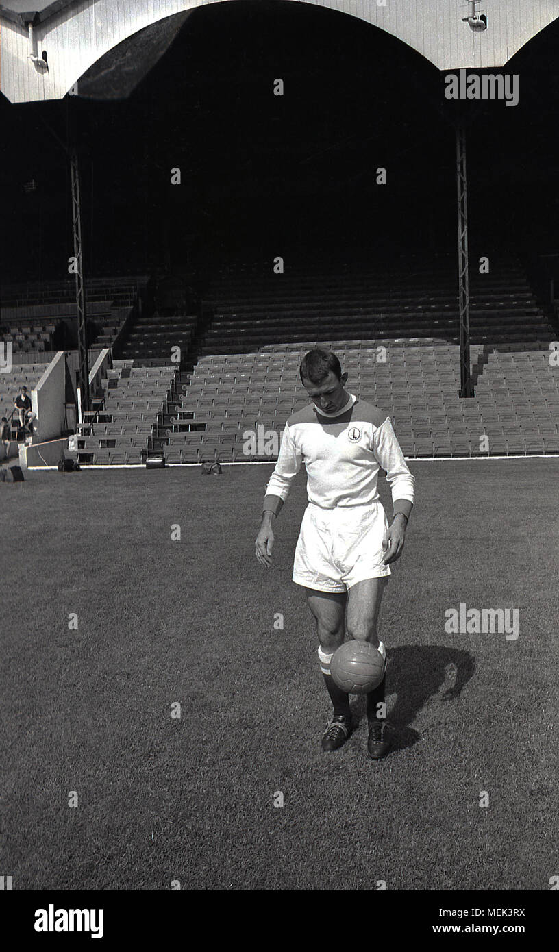 1964, Charlton Athletic FC, historische Bild, Charlton Fußballer Mike Bailey im Tal die Kick-up tragen ihre neuen Fußball-Kit. Zwischen 1964 und 1966 die Charlton Spieler trugen eine neue alle weißen Kit mit roten Schultern und die Hand und sowrd Abzeichen zuerst auf dem Shirt erschienen. Stockfoto