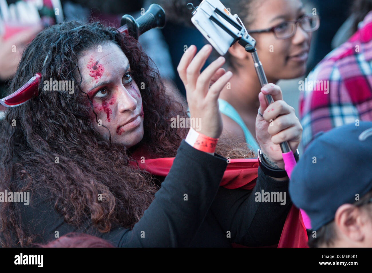 Eine junge Frau in Zombie Make-up und trägt eine gefälschte Messer durch den Kopf, nimmt eine selfie am Cherokee Zombie Fest am 17. Oktober 2015 im Bezirk, GA. Stockfoto