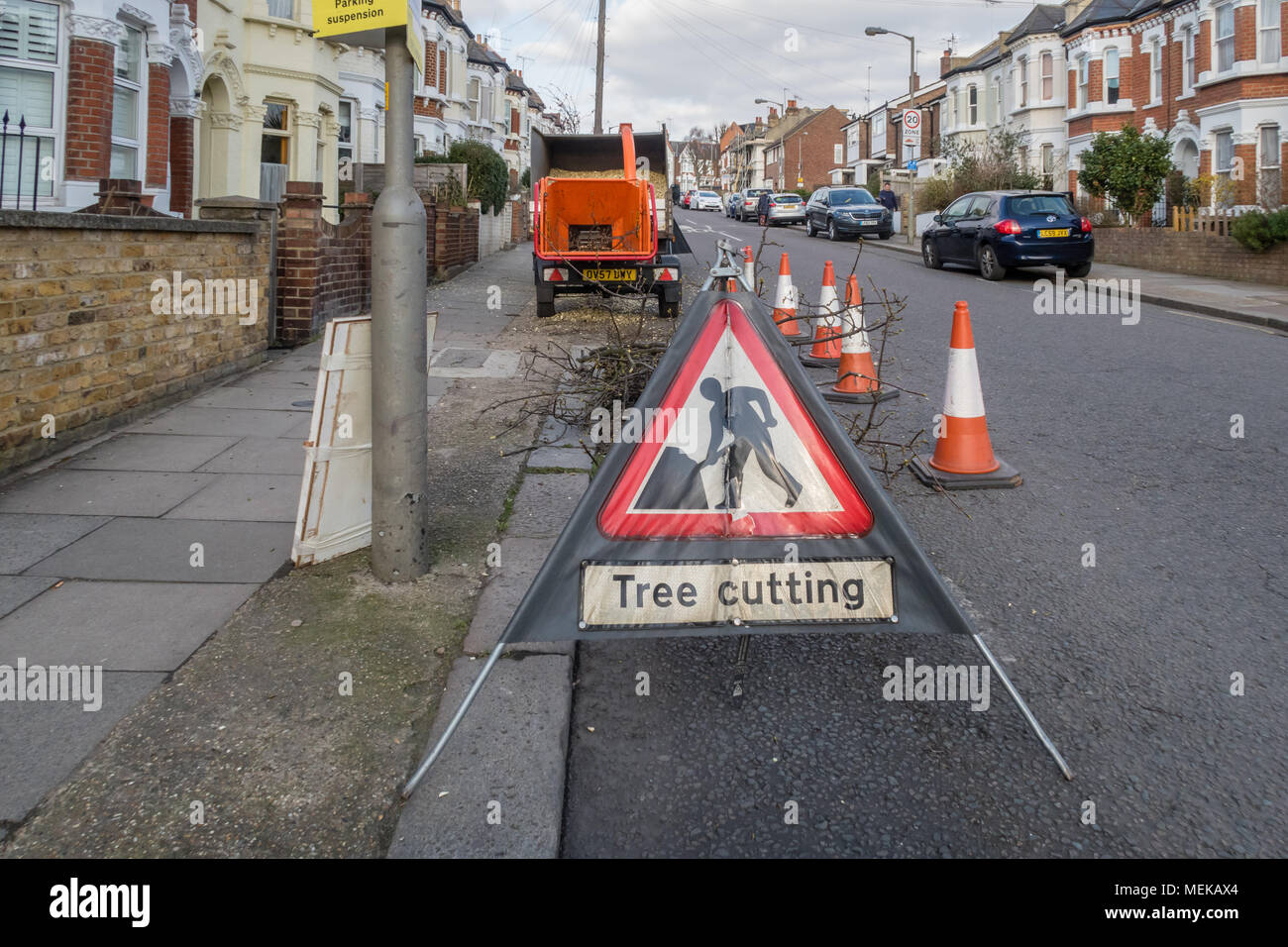 Ein Schild mit der Aufschrift Baum schneiden mit einem Wood chipper Maschine im Hintergrund. Stockfoto