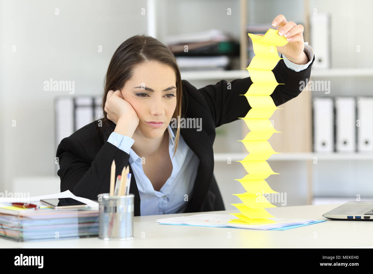 Gelangweilt executive verschwenden Zeit beim Spielen mit Erinnerungen im Büro Stockfoto