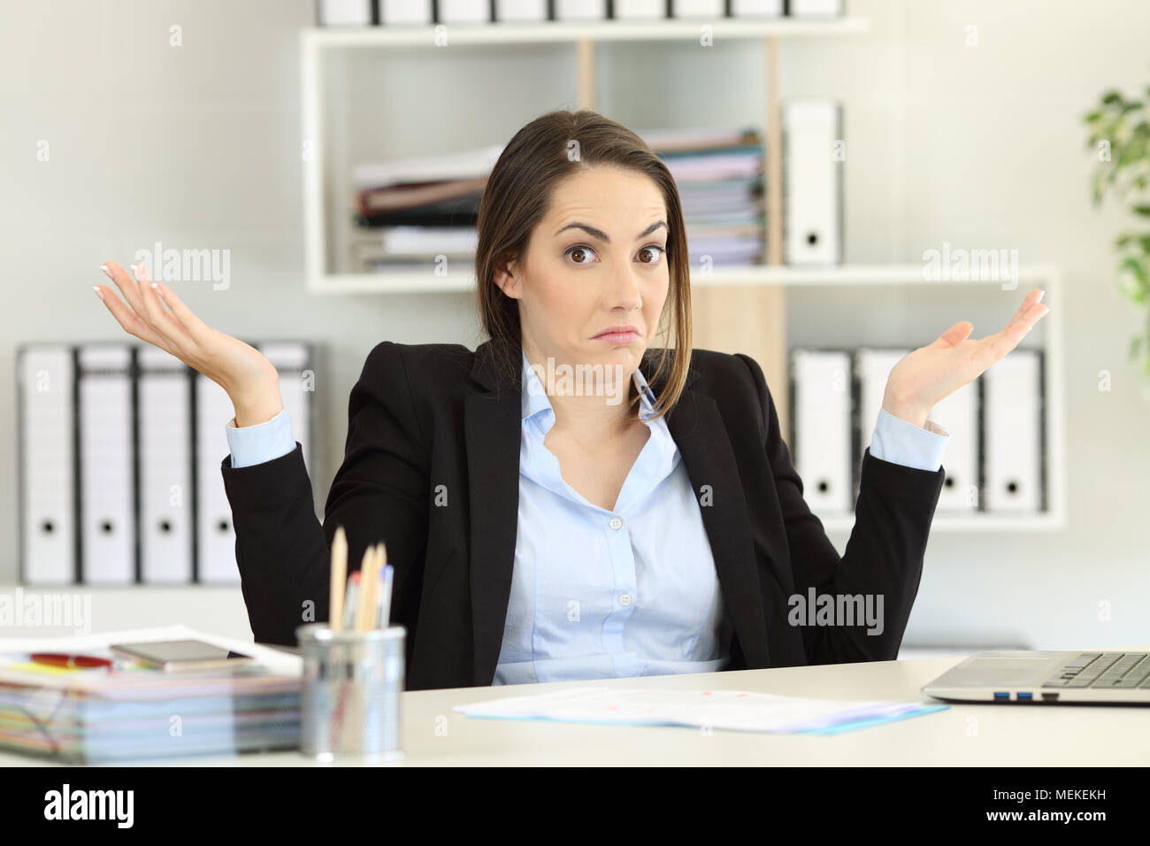 Vorderansicht Porträt eines verwirrten Geschäftsfrau Achselzucken an Kamera im Büro suchen Stockfoto
