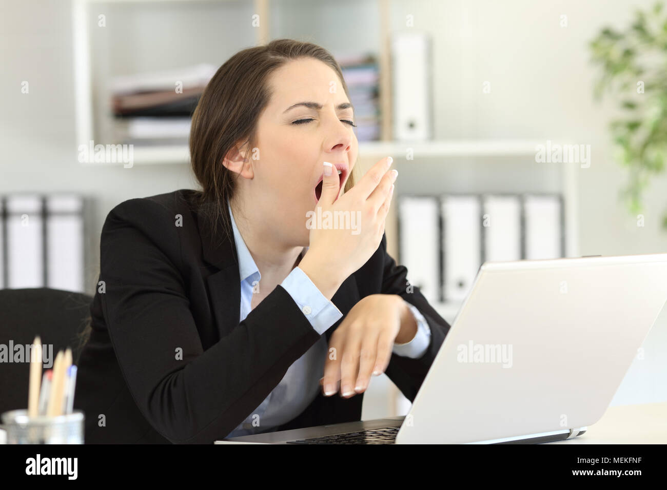 Müde executive Gähnen und über den Mund mit der Hand im Büro Stockfoto
