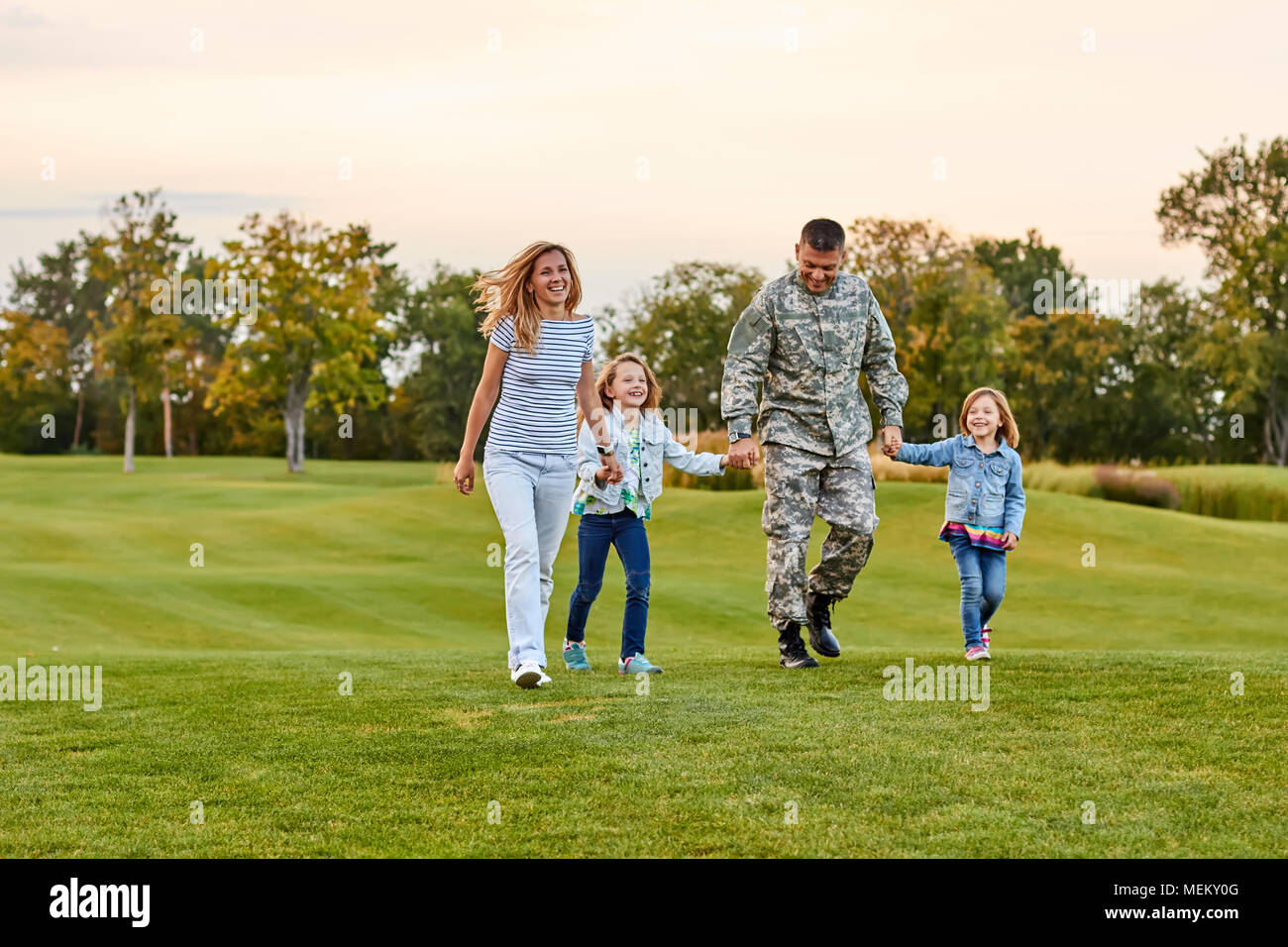 Glückliche Familie zu Fuß auf dem Gras. Stockfoto