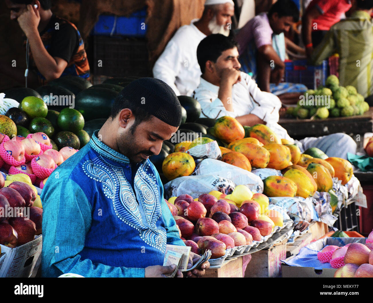 Obst Verkäufer auf einem in der Crawford Marktstand, sein Geld zählen und mit seinen Einnahmen, Mumbai, Indien zufrieden Stockfoto