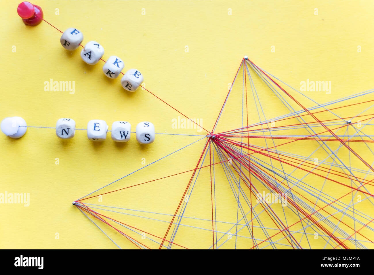 Beschriftete Perlen von Seil und Nägel auf gelben Hintergrund Visualisierung gefälschte Nachrichten im Netzwerk Stockfoto