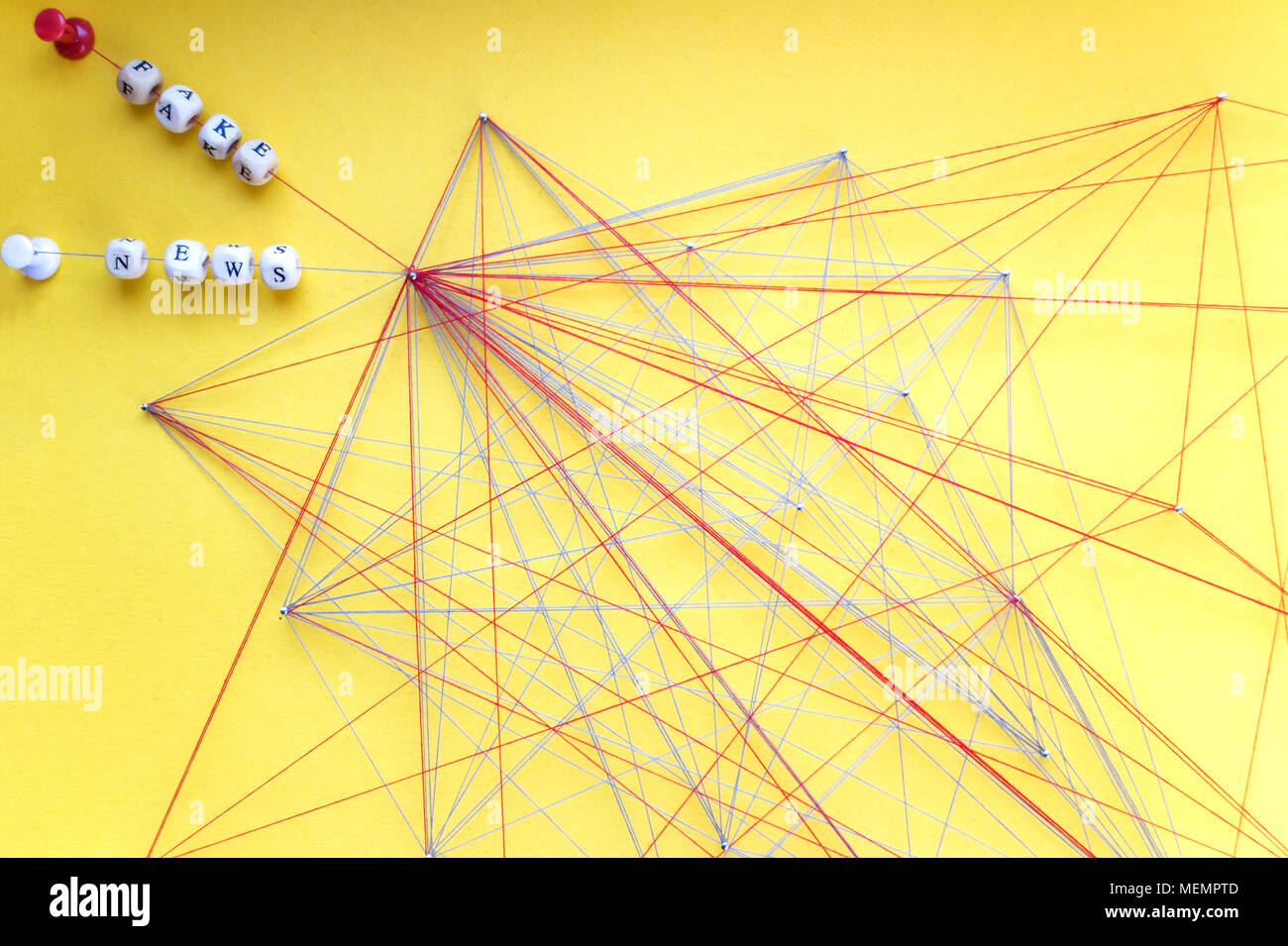 Beschriftete Perlen von Seil und Nägel auf gelben Hintergrund Visualisierung gefälschte Nachrichten im Netzwerk Stockfoto
