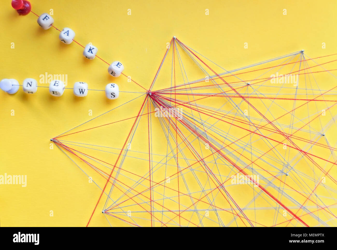 Beschriftete Perlen von Seil und Nägel auf gelben Hintergrund Visualisierung gefälschte Nachrichten im Netzwerk Stockfoto