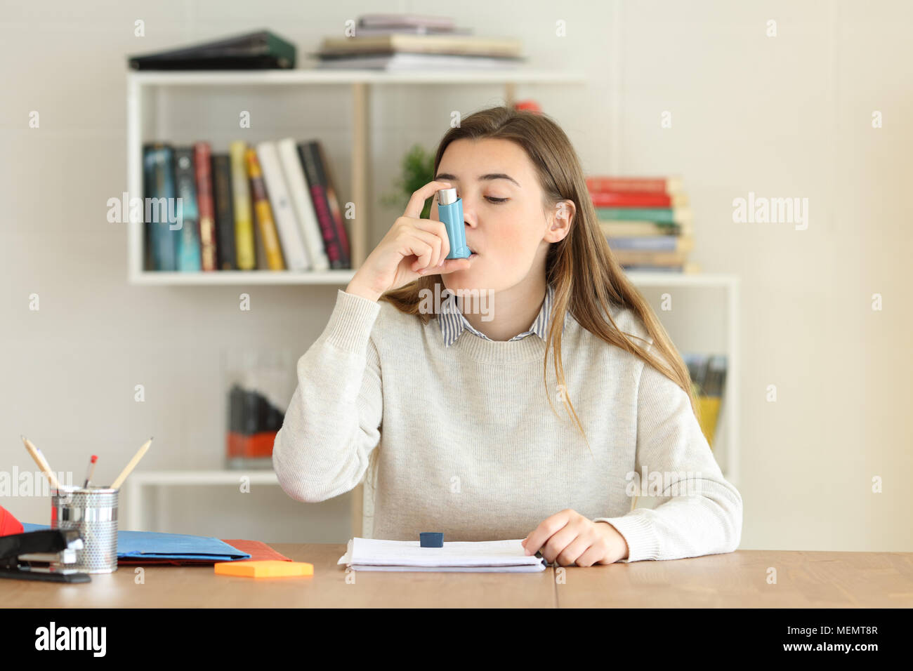 Student in einem Asthmaanfall mit einem Asthma Inhalator zu Hause Stockfoto