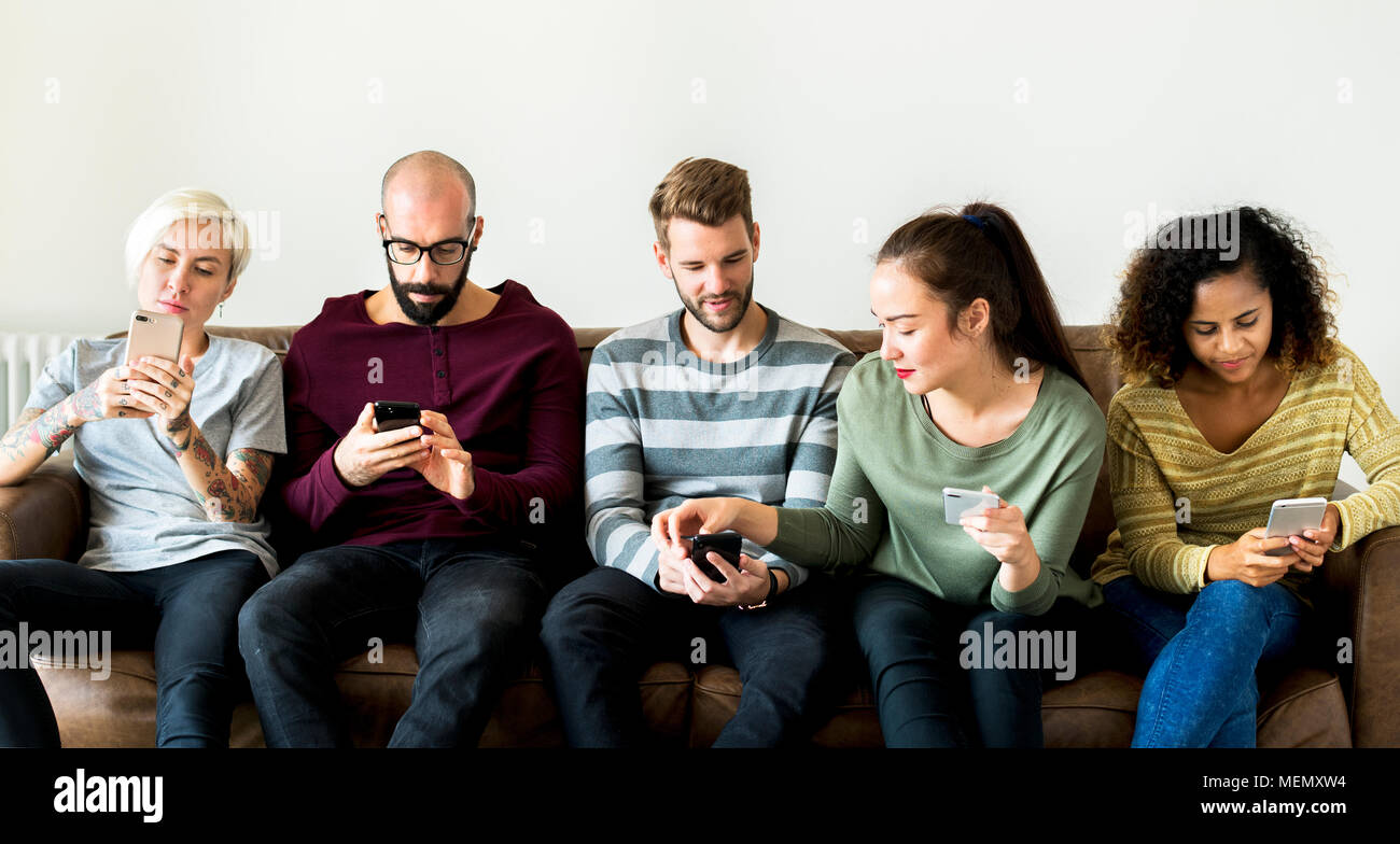 Gruppe von Menschen mit Handy auf der Couch Stockfoto