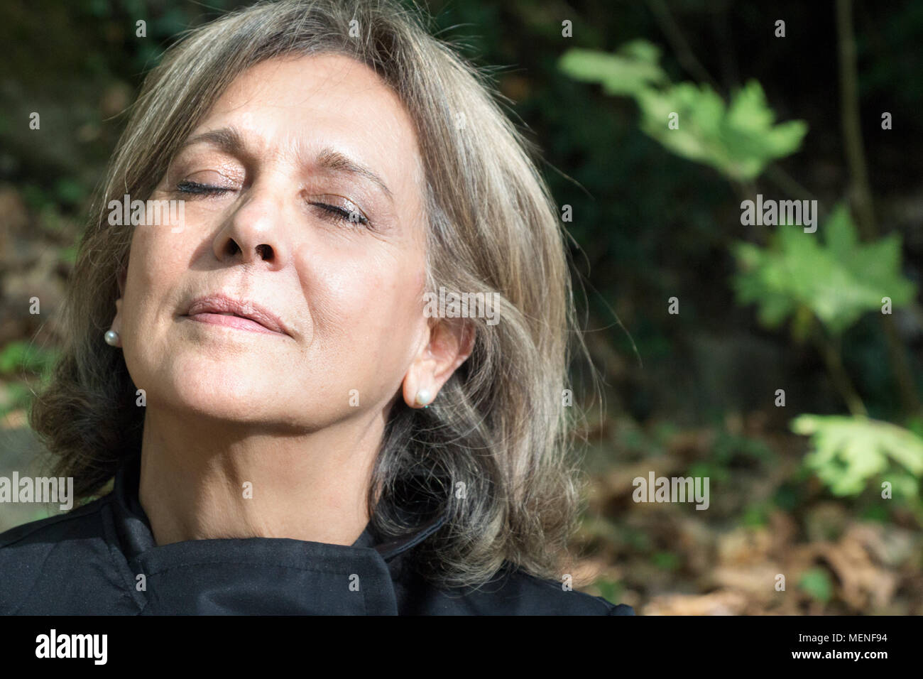 Porträt einer reifen Frau mit geschlossenen Augen entspannt, im Freien. Stockfoto