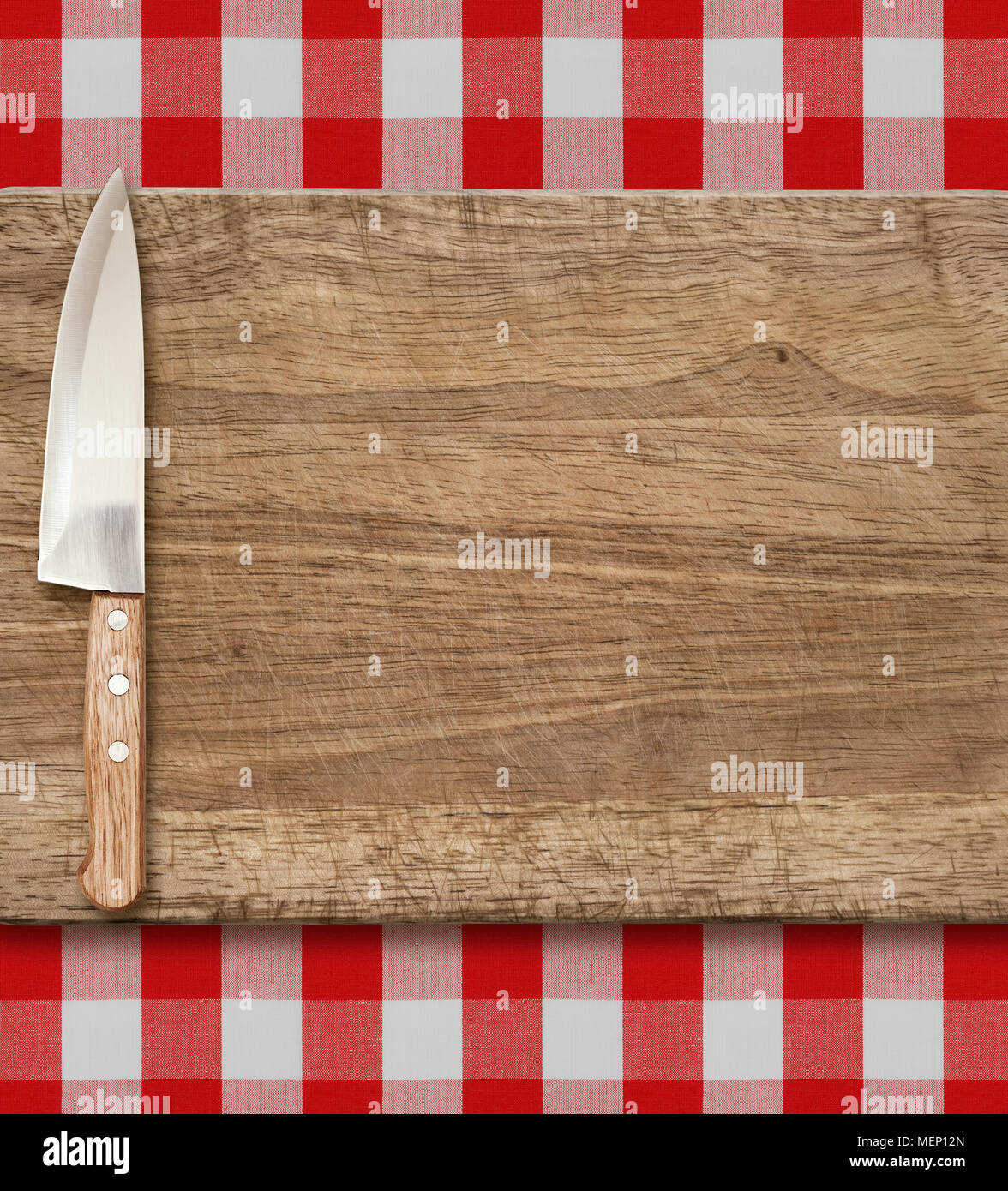 Schneiden Breadboard und Küchenmesser. Kochen über rot kariertem Tischtuch. Stockfoto