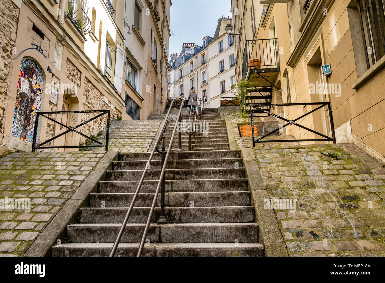 Eine Frau steigt die steilen Stufen der Passage de Abbesses in Montmartre, Paris Stockfoto