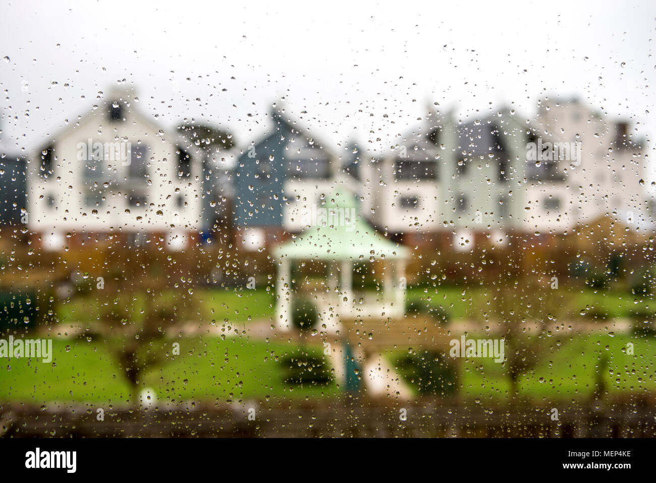 Moderne Häuser gesehen durch ein nasses Fenster. Stockfoto