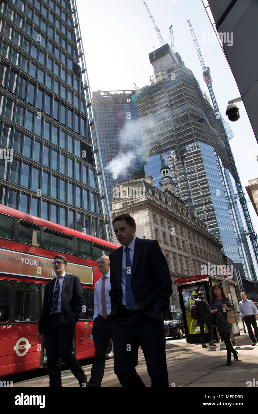 Die Verschmutzung aus dem Schornstein eines alten Gebäudes gießt in die Atmosphäre unter den modernen Glas Gebäude in der City of London, London, England, Vereinigtes Königreich. Auf der Straße, Busse und Verkehr passieren hinzufügen, um die Emissionen, und alle bis auf die schlechte Luft, die die Menschen atmen auf einer täglichen Basis. London versucht, die Luftqualitätsziele zu erreichen. Die Europäische Air Quality Index, die von der Europäischen Umweltagentur EEA und der Europäischen Kommission, kann der Benutzer die aktuelle die Luftqualität in den Städten und Regionen Europas zu prüfen. Umweltschutzverbaende bezeichneten die für die Regierung Stockfoto