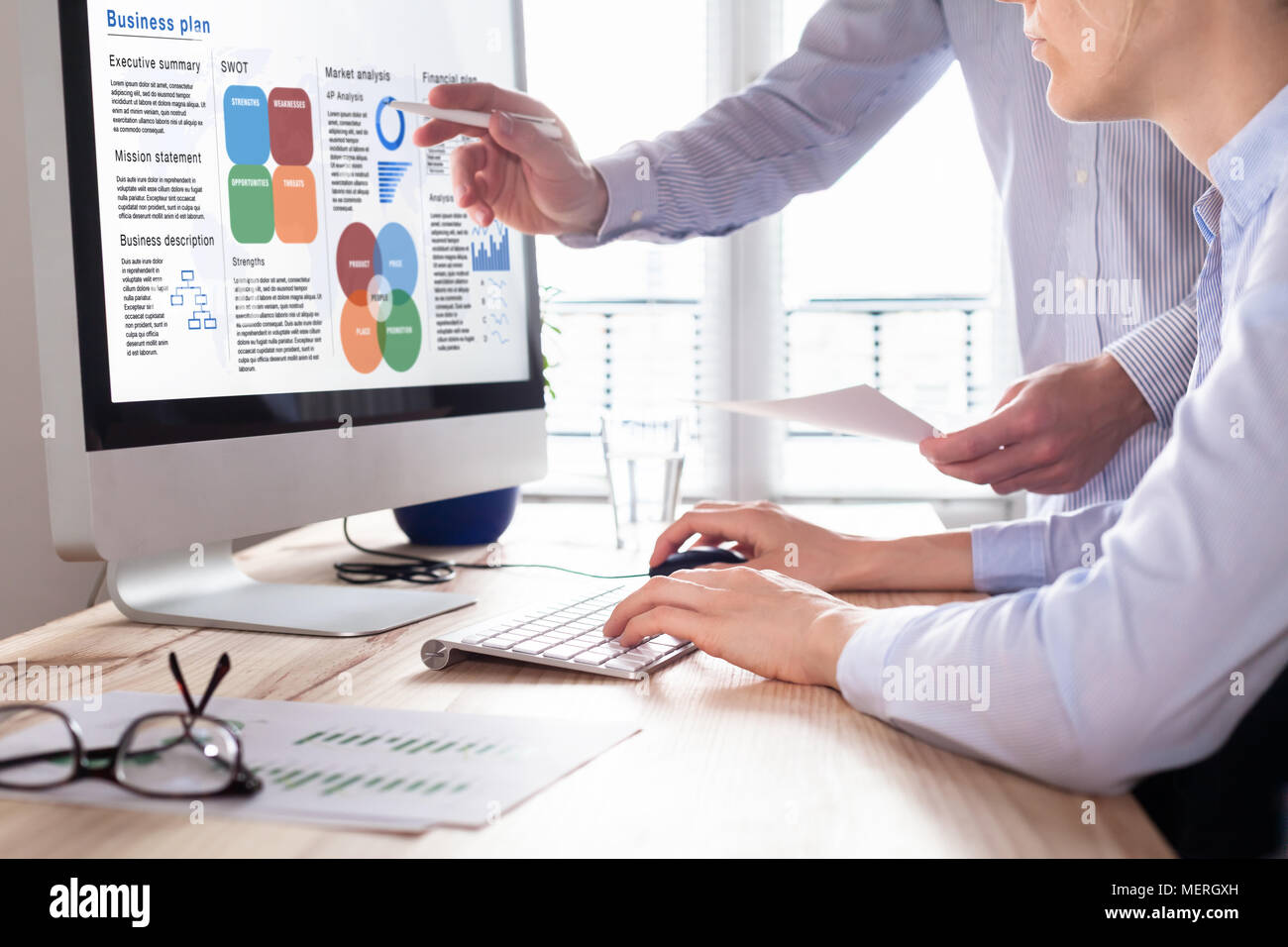 Mixed Team von Beratern arbeiten an einem Business Plan Bericht auf Bildschirm mit einer Zusammenfassung für Führungskräfte, Strategie Informationen Daten, SWOT, Markt Analysi Stockfoto