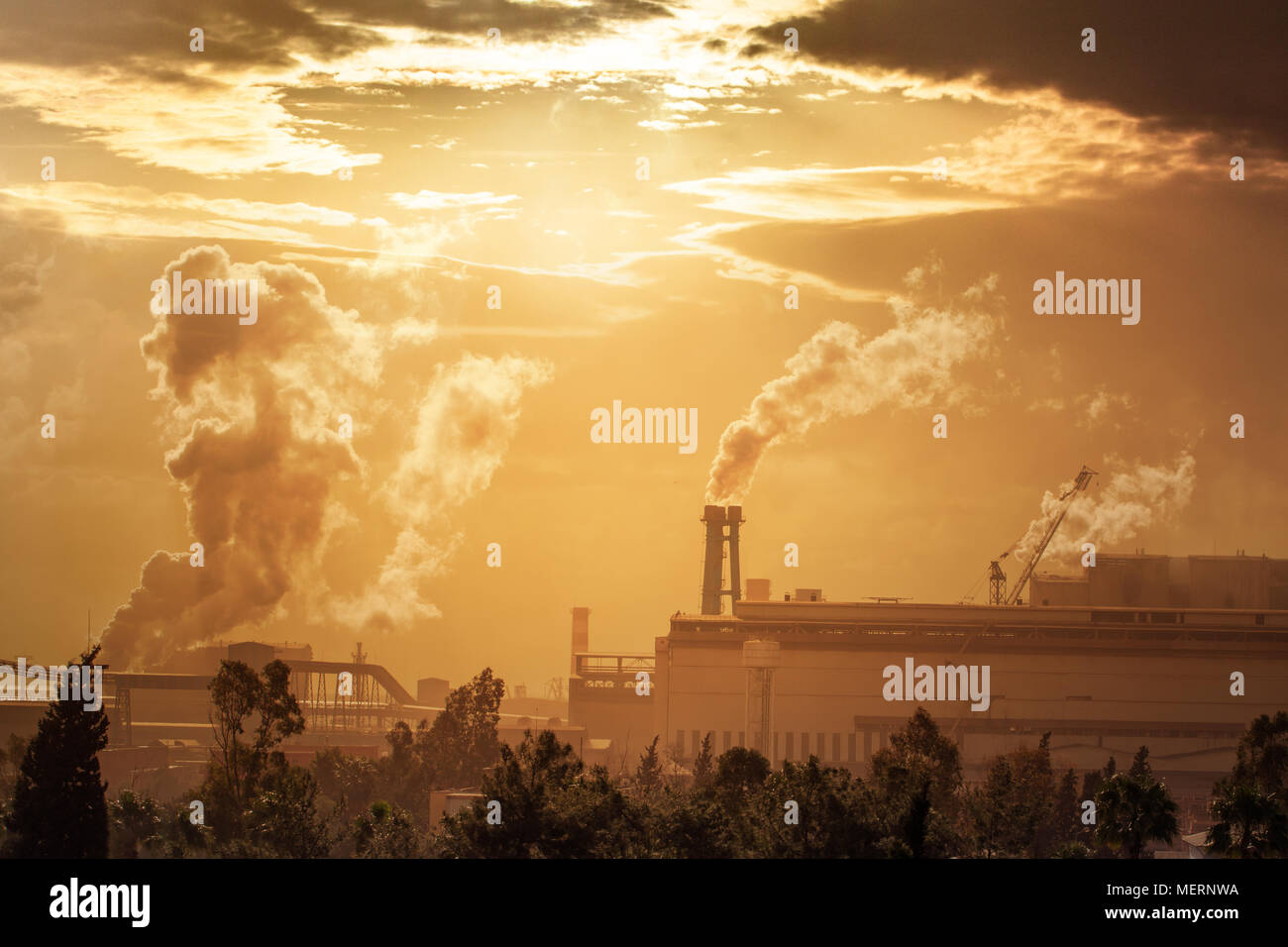 Umweltverschmutzung durch die Industrie. Industrielle Landschaft bei Sonnenuntergang Himmel. Hüttenwerk verschmutzt die Luft. Rohre mit Rauch auf die Horizontlinie. Stockfoto