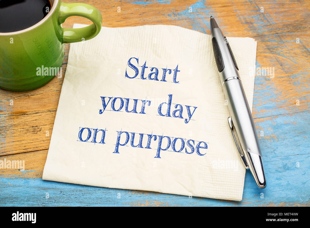 Beginnen Sie Ihren Tag auf Zweck - inspirational Handschrift auf eine Serviette mit einer Tasse Kaffee Stockfoto