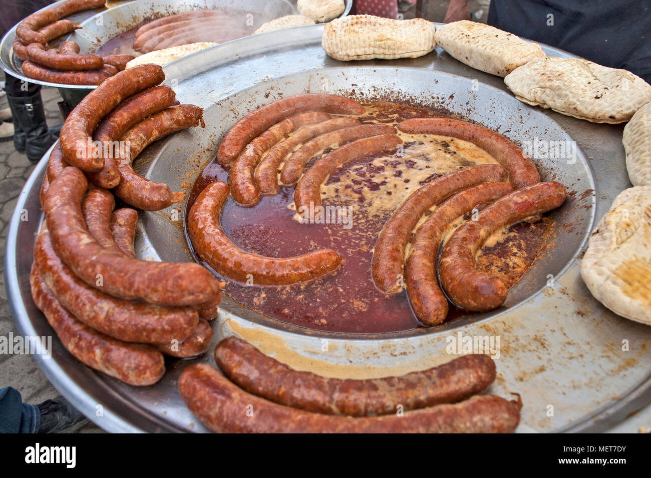 Ein Mann bereitet traditionell Würstchen draußen auf der Straße zu verkaufen. Stockfoto