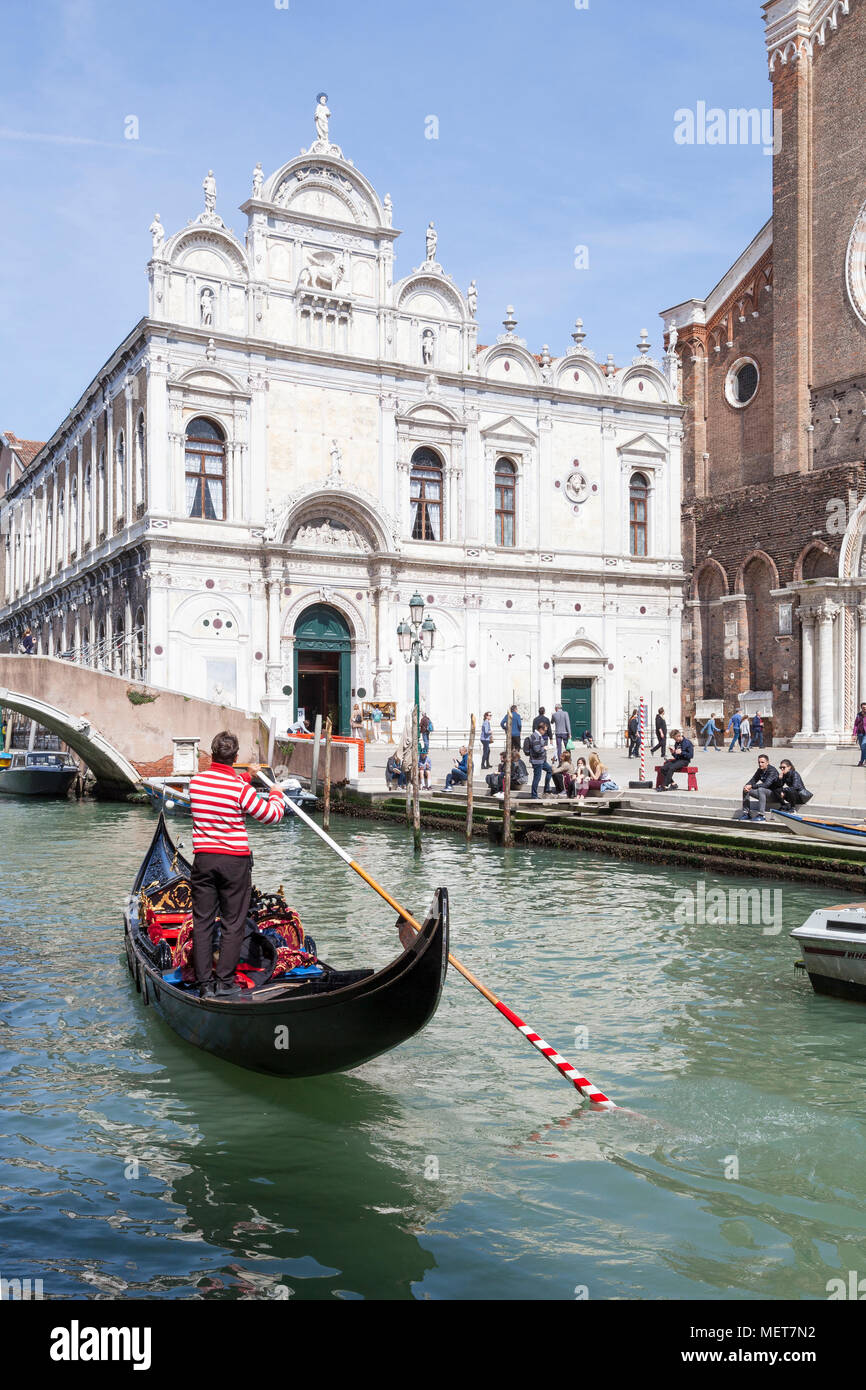 Scuola Grande di San Marco, Campo dei Santi Giovanni e Paolo, Castello, Venedig, Venetien, Italien mit einer Gondel und gondoliere Rudern auf dem Kanal Stockfoto