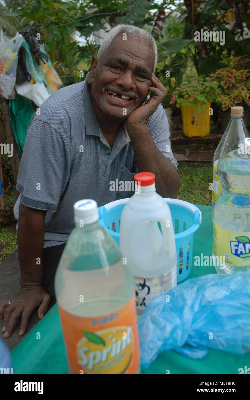 Alte Fijian Mann mit Tisch voller Getränke Stockfoto