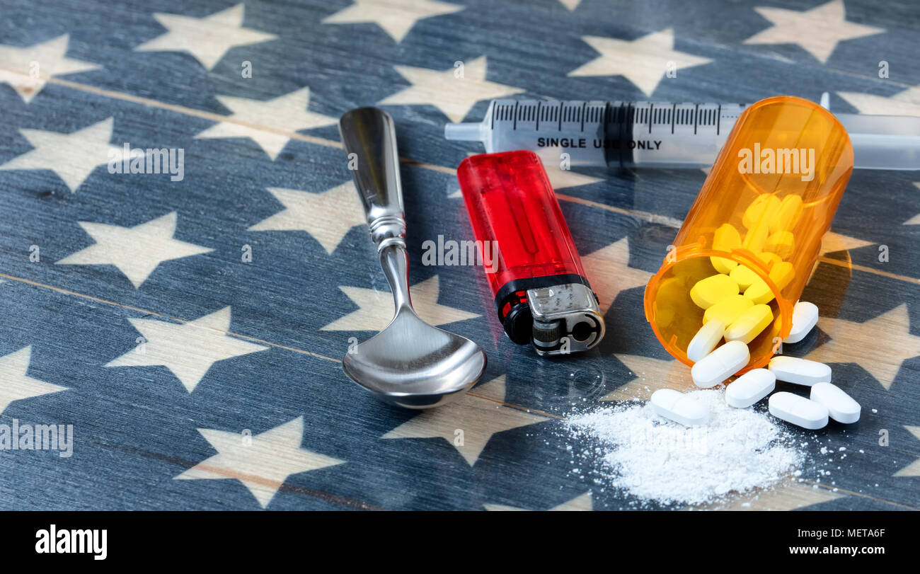 Vorderansicht von Opioiden Schmerzmittel Tabletten mit Löffel, leichter und Spritze auf rustikalen USA-Flagge im Hintergrund für die Drogenabhängigkeit Konzept in Amerika Stockfoto