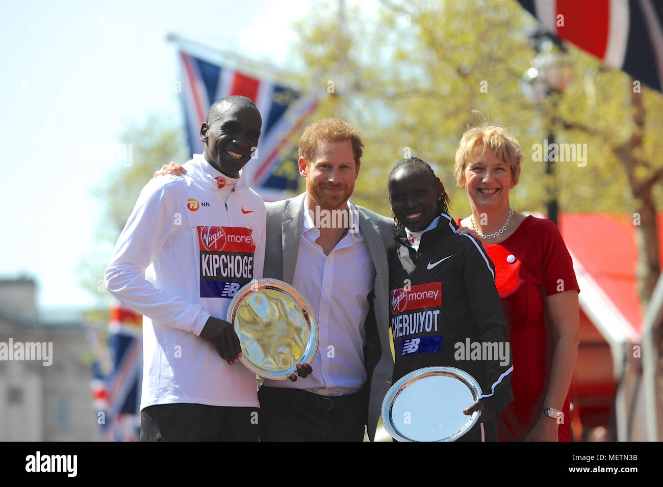 Elud Kipchoge (KEN) und Vivian Cheruiyot (KEN) auf dem Podium mit Seiner Königlichen Hoheit Prinz Harry und Anne Gadhia (CEO von Virgin Money UK) bei der Siegerehrung für die Virgin Money London Marathon Rollstuhl Rennen, die Mall, London, Vereinigtes Königreich. Eliud Kipchoge hatte zuvor seinen Status als der König der Marathon als bestätigt, wenn er Rennen der Virgin Money London Marathon Männer zum dritten Mal mit einer Zeit von 2:04:17 gewonnen. Cheruiyot lief ein perfekt beurteilt Rennen den Titel im Rennen der Elite Frauen zu nehmen und das Vierte schnellsten Frau aller Zeiten über die anstrengenden Marathon dis Stockfoto