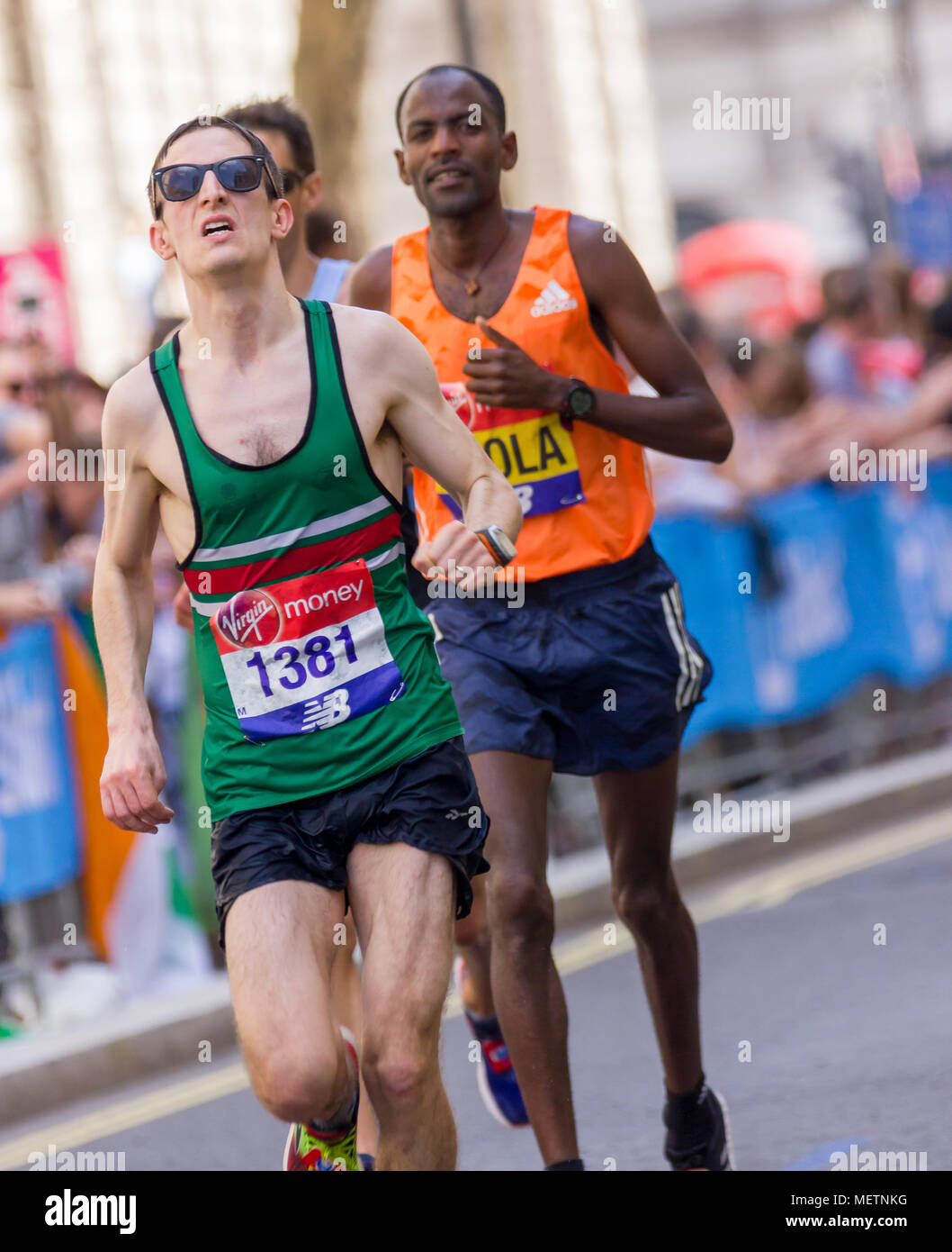 St James's Park, Birdcage Walk, London, UK. 22. April 2018. Elite und Tausende von fun Läufer in Richtung Buckingham Palace in brillanter Frühlingssonne, wie sie die letzte Meile der Virgin London Marathon 2018 eingeben. Einige der Teilnehmer waren betroffen, durch die einer der heißesten Marathons Tage auf und brauchten die Hilfe anderer Läufer die letzten km abzuschließen, als sie in der Mall, während andere angefahren wurden von Erste Hilfe Besatzungen behandelt. Leider einer der Läufer, Matt Campbell, 29 Jahren, brach nach 22,5 Meilen und starb später im Krankenhaus. Credit: Alan Fraser Stockfoto