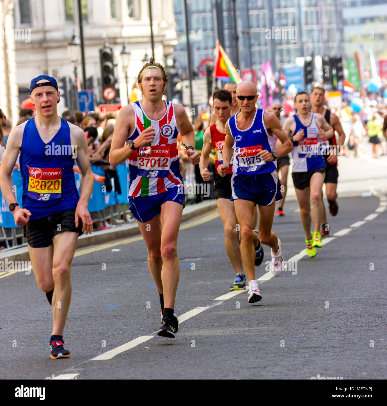 St James's Park, Birdcage Walk, London, UK. 22. April 2018. Elite und Tausende von fun Läufer in Richtung Buckingham Palace in brillanter Frühlingssonne, wie sie die letzte Meile der Virgin London Marathon 2018 eingeben. Einige der Teilnehmer waren betroffen, durch die einer der heißesten Marathons Tage auf und brauchten die Hilfe anderer Läufer die letzten km abzuschließen, als sie in der Mall, während andere angefahren wurden von Erste Hilfe Besatzungen behandelt. Leider einer der Läufer, Matt Campbell, 29 Jahren, brach nach 22,5 Meilen und starb später im Krankenhaus. Credit: Alan Fraser Stockfoto