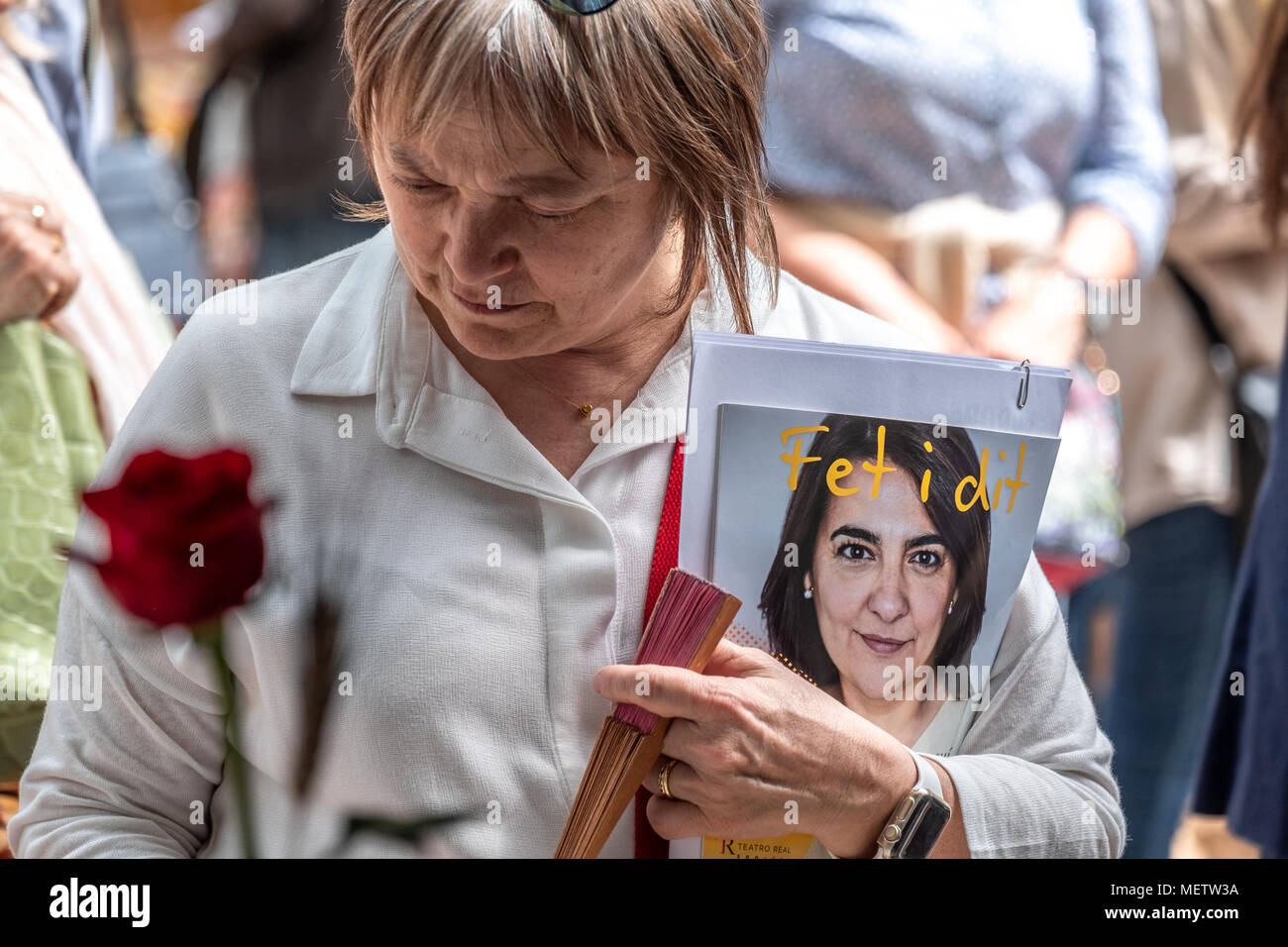 Barcelona, Katalonien, Spanien. 23 Apr, 2018. Eine Frau ist auf der Suche nach Bücher in den Ställen in der Nähe von Las Ramblas. Catalunya feiert die ''Day von Sant Jordi'', der Tag der Bücher und Rosen. Catalunya hofft zu erreichen, die Zahl von 7 Millionen Rosen verkauft. Es ist Tradition eine Rose oder ein Buch bei Liebhabern zu geben. Zahlreiche literarische Autoren signieren ihre Bücher der Öffentlichkeit auf die Straße. Credit: ZUMA Press, Inc./Alamy leben Nachrichten Stockfoto