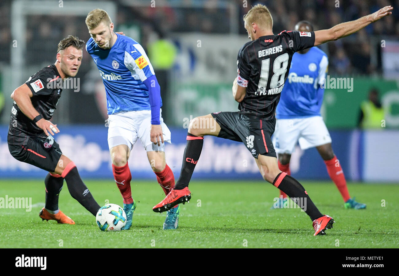 23 April 2018, Deutschland, Kiel: Fussball, Bundesliga, Holstein Kiel gegen  1. FC Nürnberg am Holstein Stadion. Der Nürnberger Eduard Loewen (L) und  Hanno Behrens und Kieler Alexander Muehling kämpfen um den Ball.