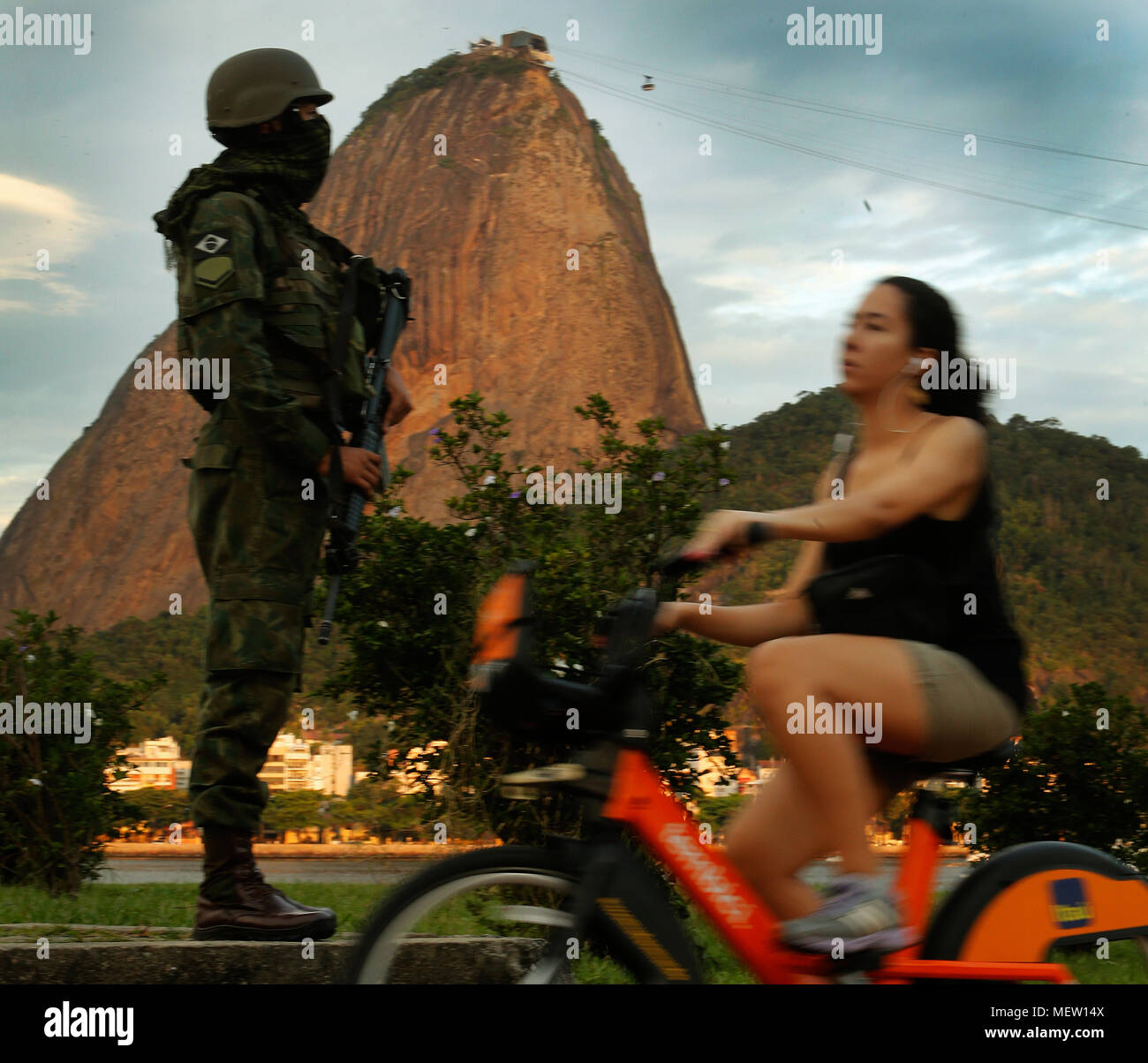 Rio de Janeiro, Brasilien. April 23rd, 2018 eine brasilianische Armee Soldat sichert einen touristischen Stelle vor den Zuckerhut Hügel als touristische Fahrten mit seinem Fahrrad. Credit: Antonio Di Paola/Alamy leben Nachrichten Stockfoto
