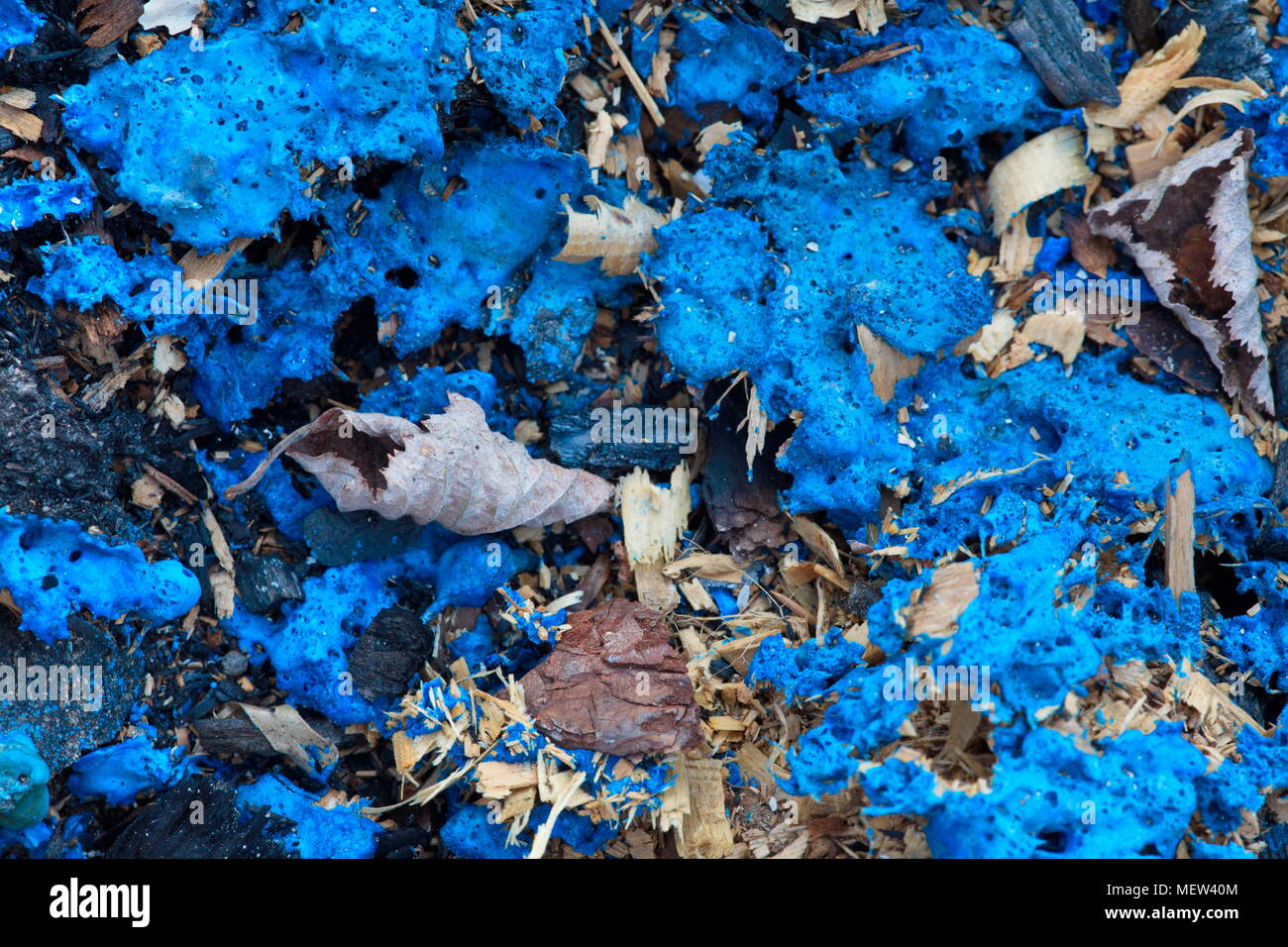 Blau geschmolzene Kunststoff ist mit einer verbrannt Müllhaufen Stockfoto