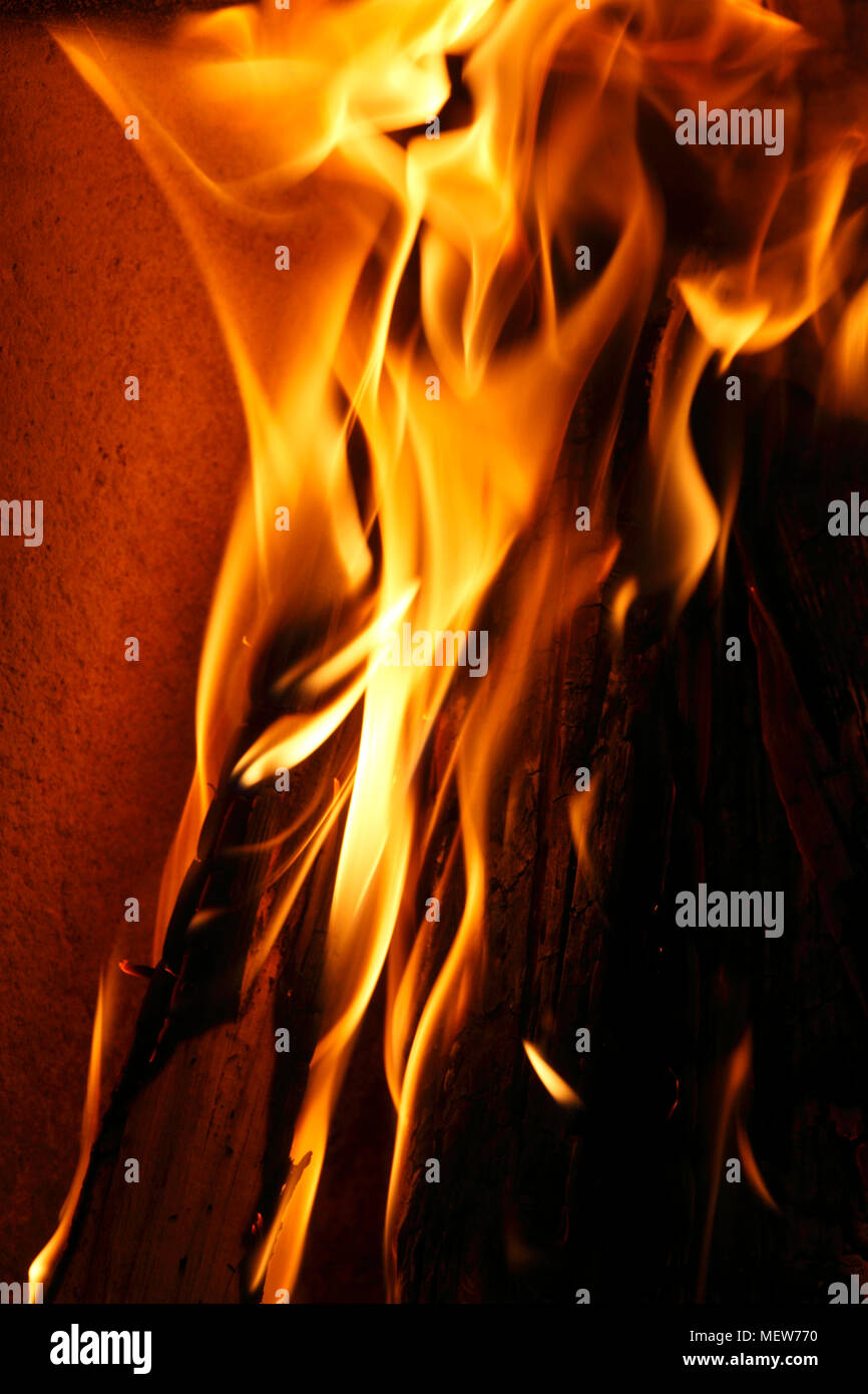 Rote Flammen steigen aus brennenden Holzscheite in den Kamin Stockfoto