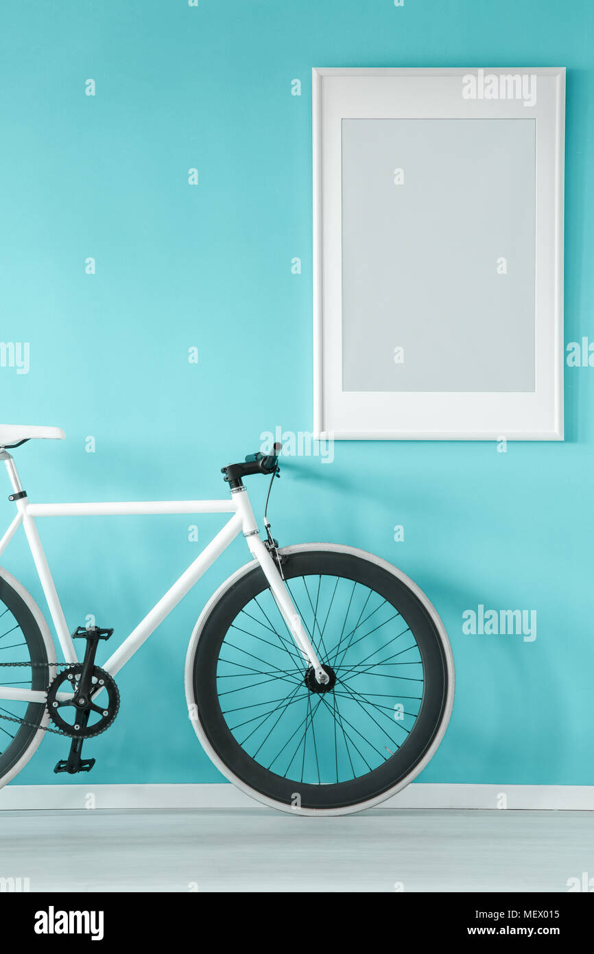 Grau Poster auf Pastell-blaue Wand im Vorraum Einrichtung mit weißen Fahrrad Stockfoto