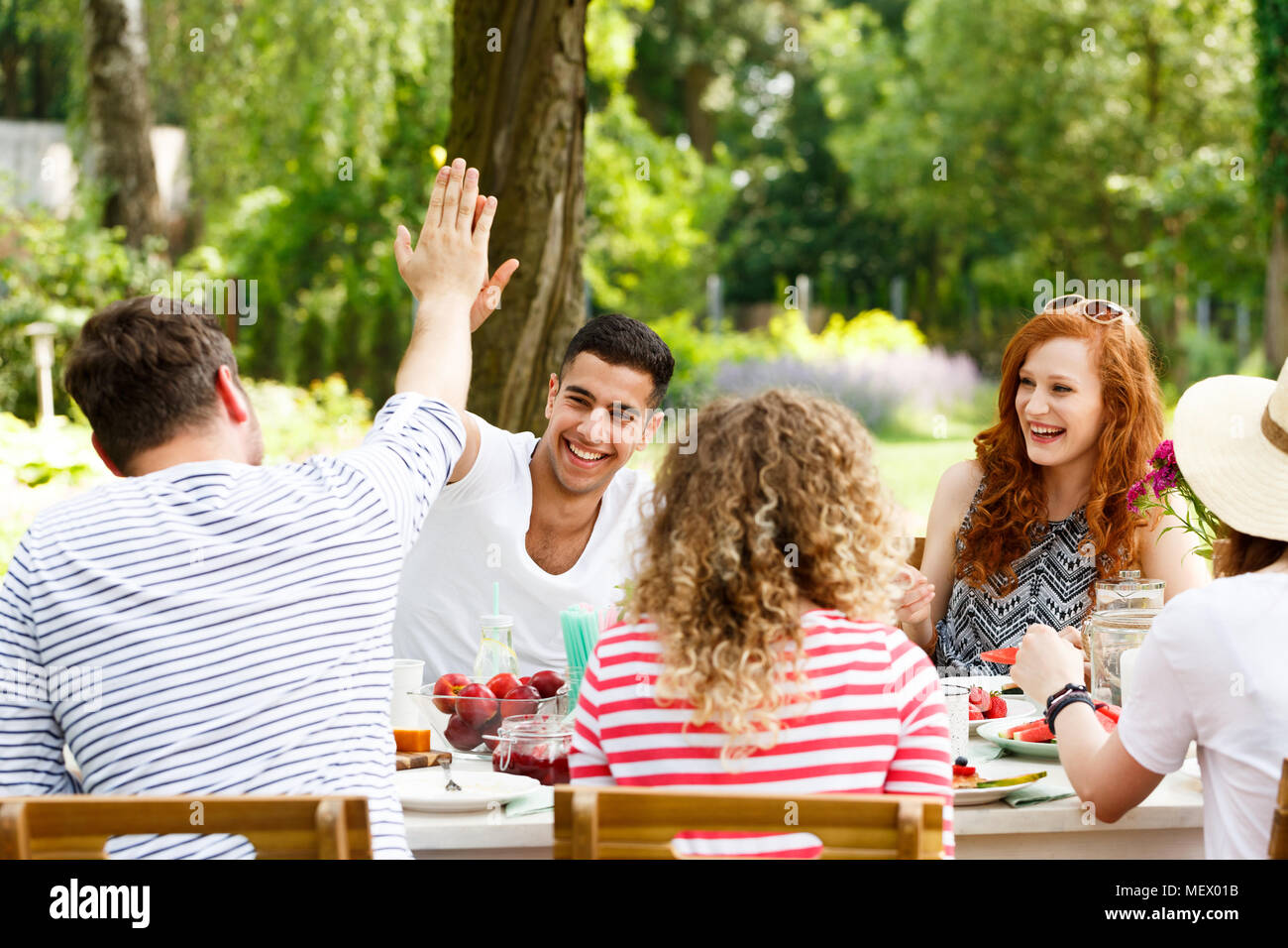 Lächelnd Gruppe von jungen Leuten Spaß, lachen und essen gesund essen außerhalb Stockfoto