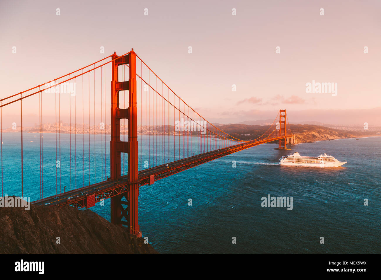 Schönen Panoramablick auf Kreuzfahrtschiff, die berühmte Golden Gate Bridge mit Blick auf die Skyline von San Francisco im Hintergrund bei Sonnenuntergang, Kalifornien Stockfoto