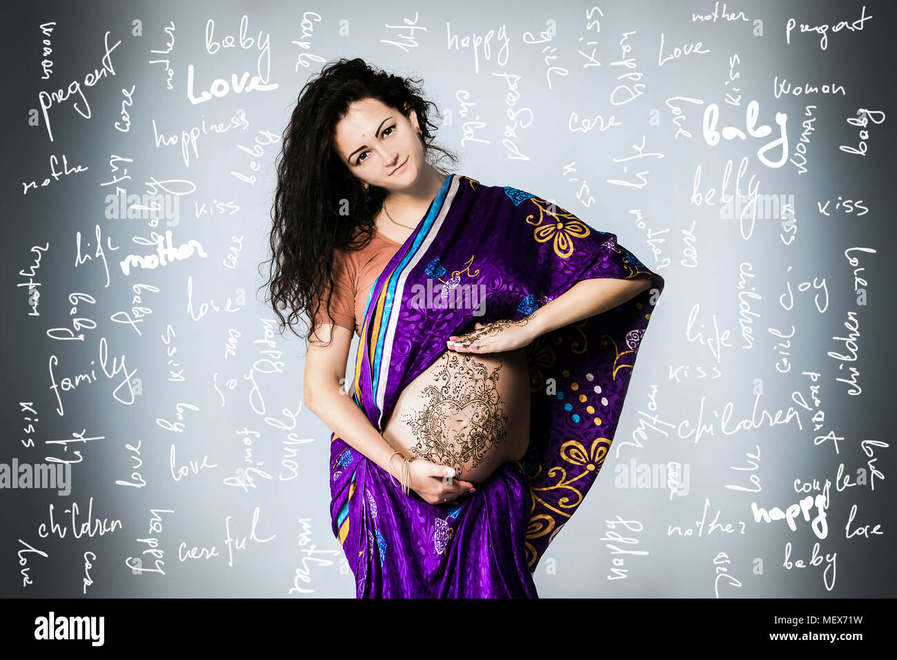Studio Portrait einer schwangeren Frau in der indischen Sari, einer schwangeren Bauch gemalt mit Henna Stockfoto