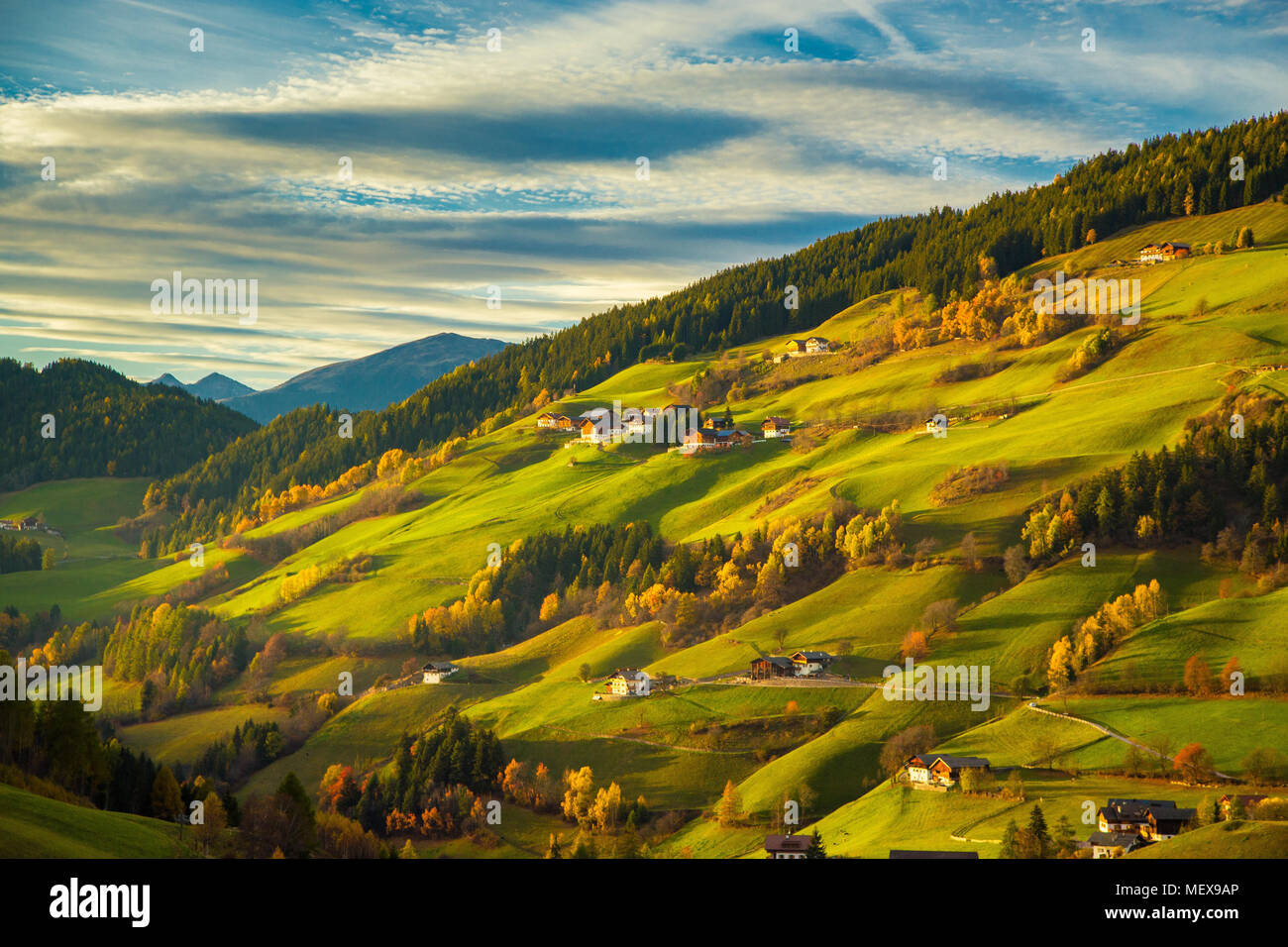 Wunderschöne Aussicht auf idyllischen Berglandschaft mit grünen Wiesen in den Dolomiten im schönen goldenen Abendlicht bei Sonnenuntergang, Val di Funes, Südtirol Stockfoto