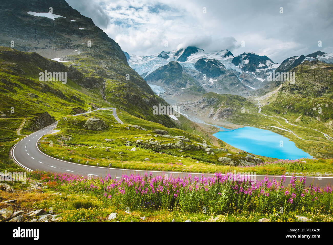 Wunderschöne Aussicht auf kurvenreichen Pass Road in den Alpen mit Gipfeln, Gletschern, Seen und grünen Wiesen mit blühenden Blumen im Sommer Stockfoto