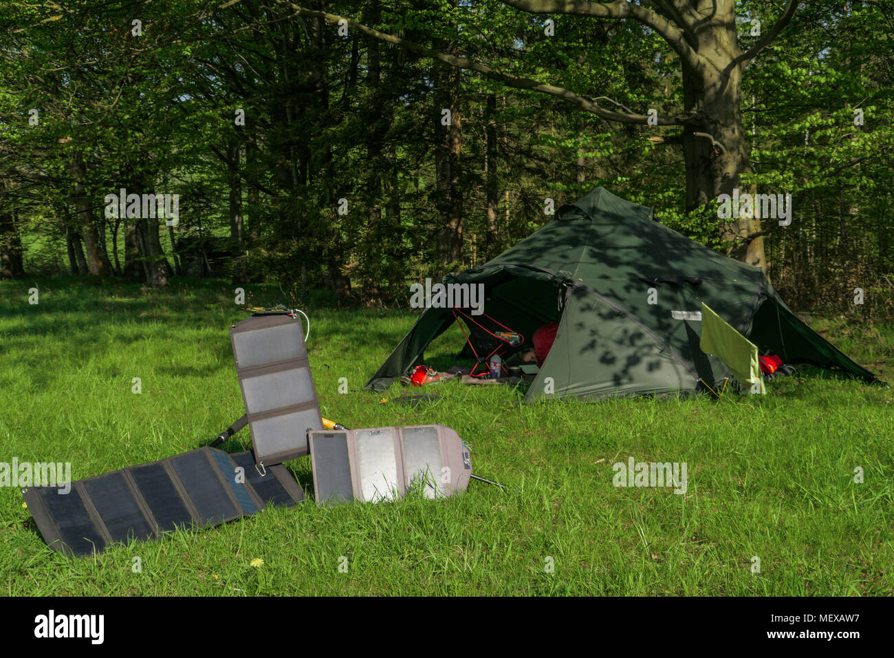 Campingplatz - großes Zelt und drei tragbare Solarzellen zum Aufladen der Batterien Stockfoto