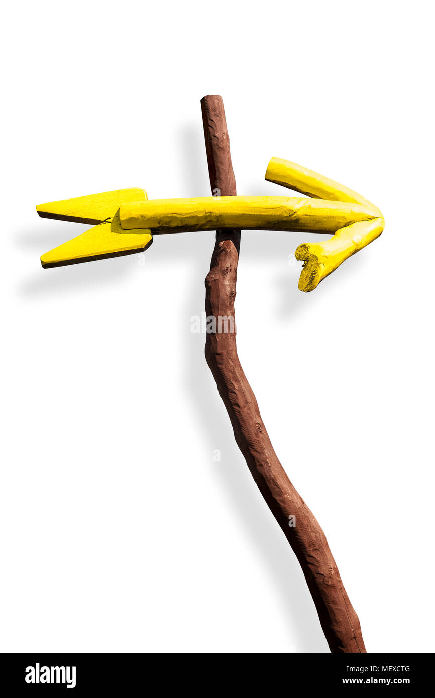 Ein Pfeil Zeichen Hand aus Holz, gelb lackiert, hängt am Zweig. Auf weiß isoliert. Pfad enthalten. Stockfoto