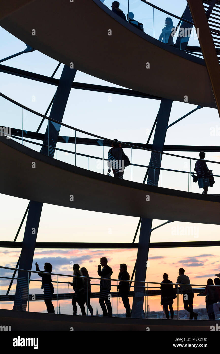 Berlin. Deutschland. Die Besucher der Reichstag Kuppel silhoutted gegen den Sonnenuntergang. Stockfoto