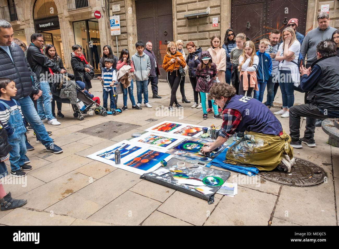 Ein Mann schafft Kunstwerke mit Sprühfarbe auf Papier in der Straße wie eine Demonstration zu Touristen. Stockfoto