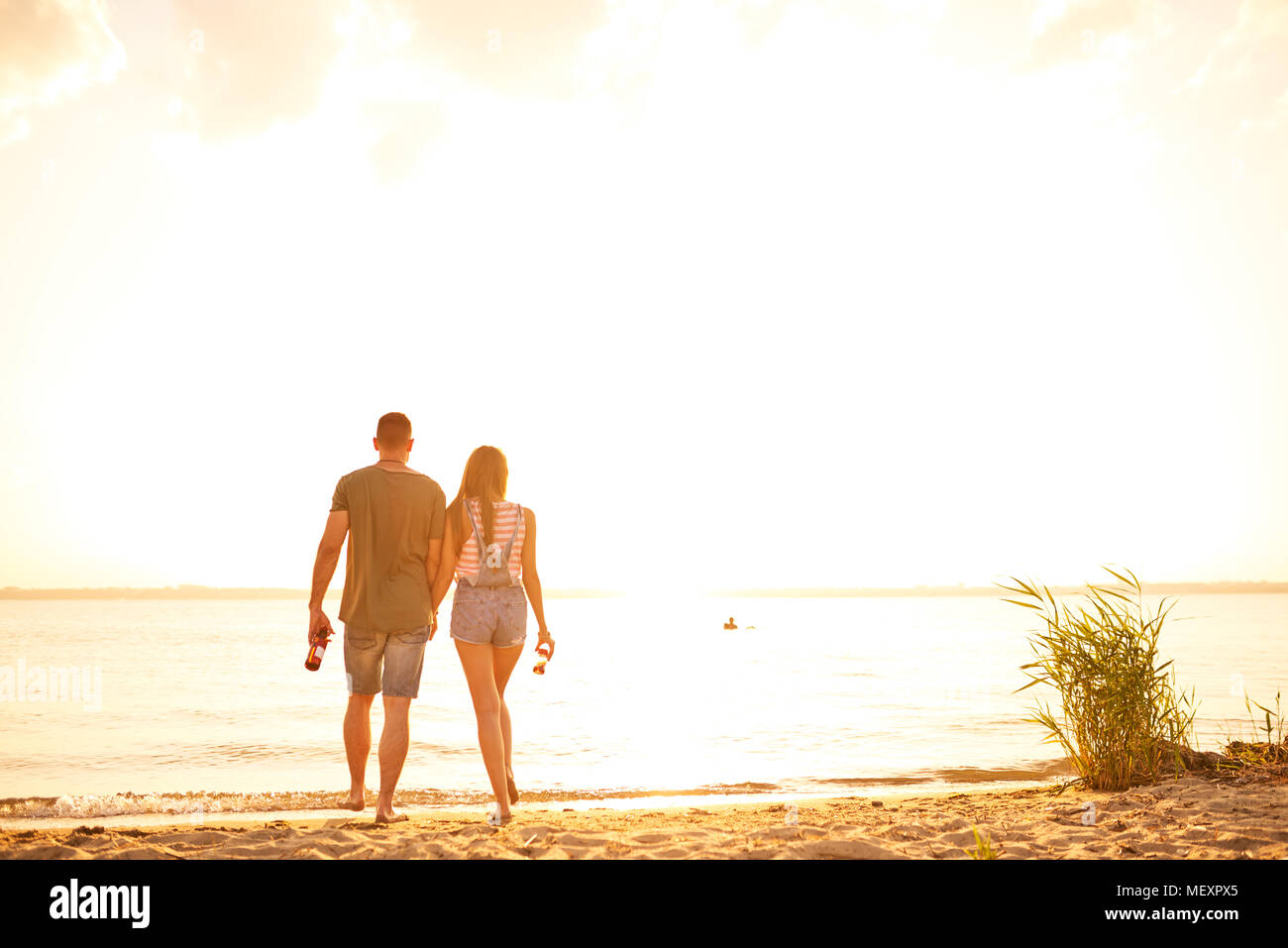 Romantisches Paar zu Fuß über den Strand in Datum Stockfoto