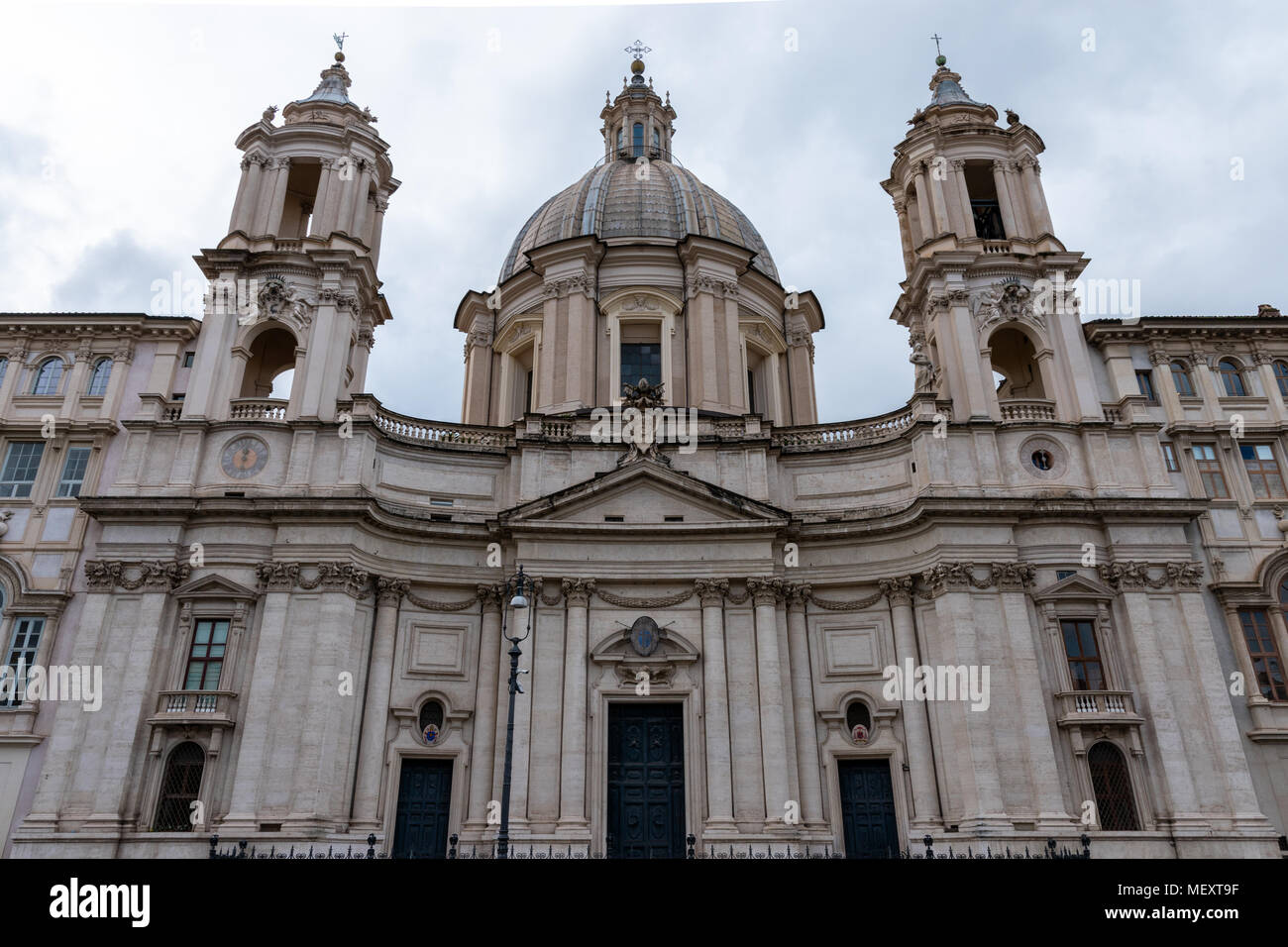 Low Angle Vorderansicht der Kirche Sant'Agnese in Agone barocke Fassade gegen bewölkter Himmel auf der Piazza Navona, Rom, Italien, tagsüber. Stockfoto