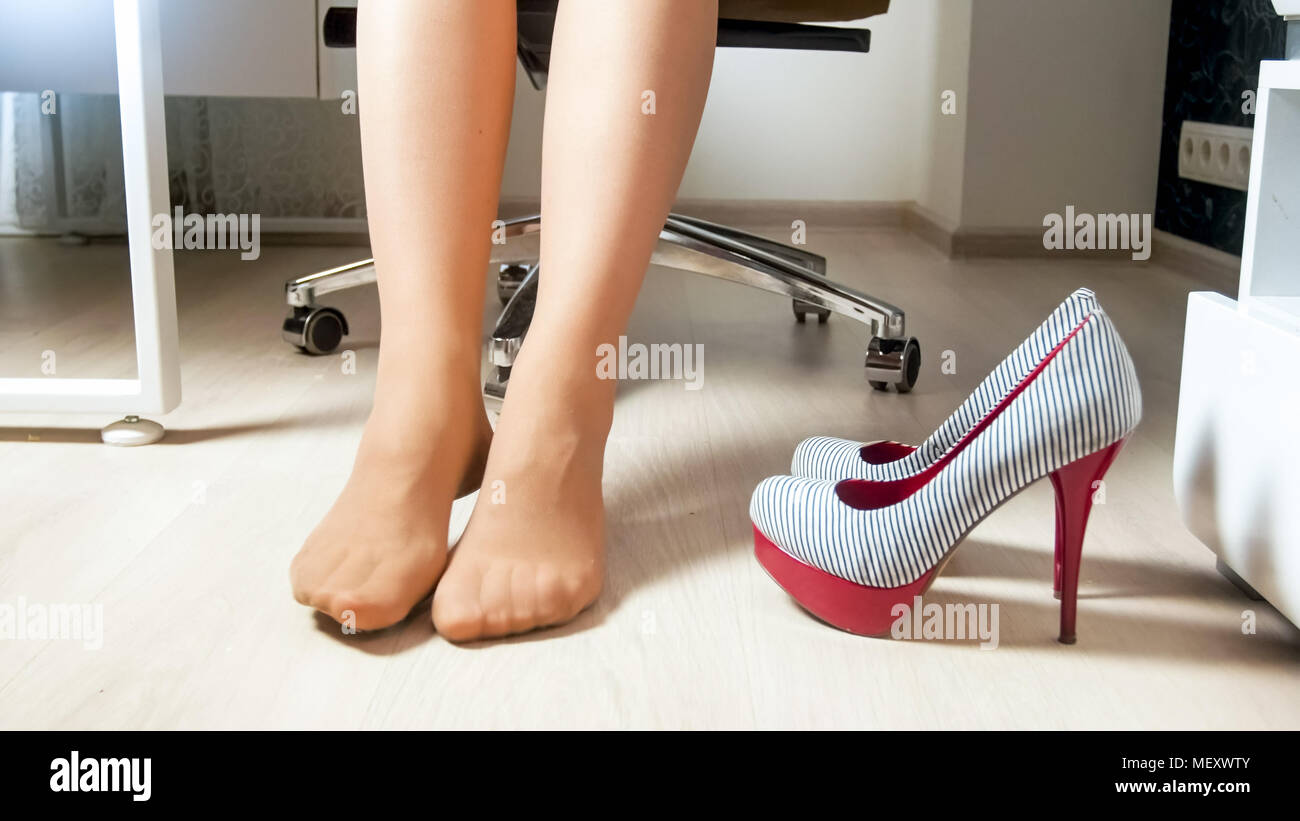 Junge weibliche Büroangestellte nahm High Heels Schuhe unter dem Tisch  Stockfotografie - Alamy