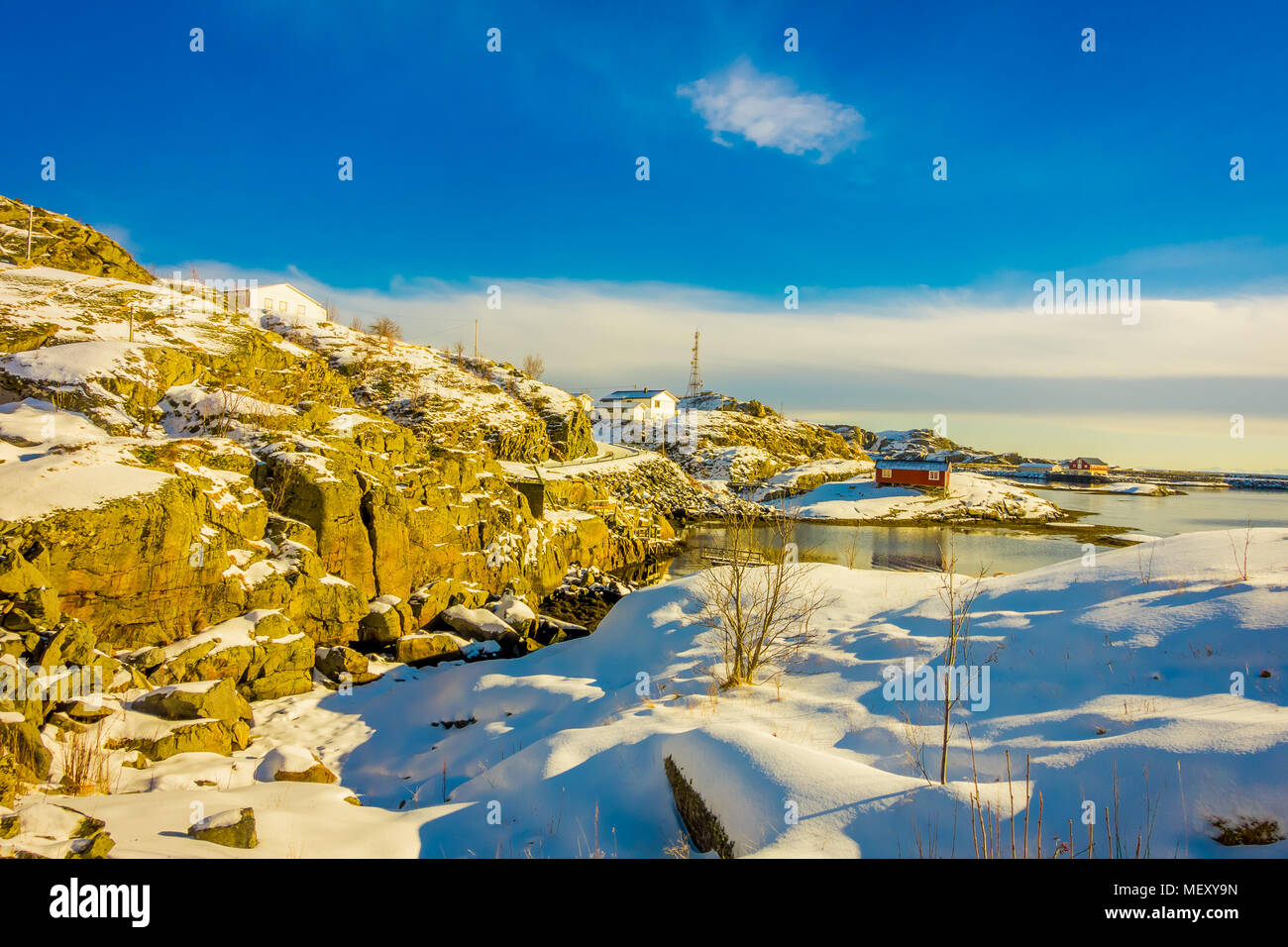 Im Freien mit einigen Gebäuden in der Bucht in Lofoten mit schneebedeckten Bergen und bunten Winter Station umgeben Stockfoto
